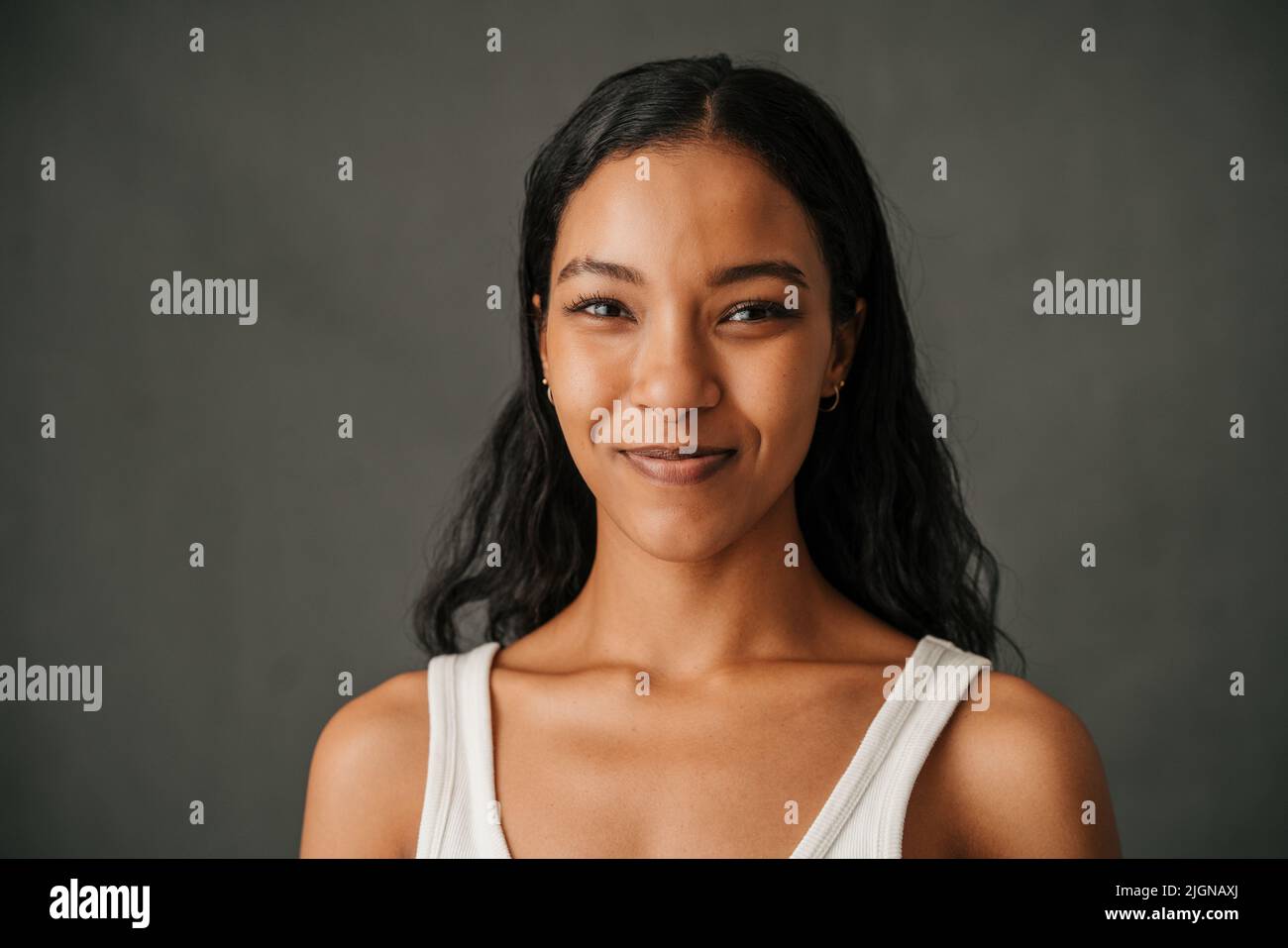 Close up dark hair African American female smiling in a studio Stock Photo