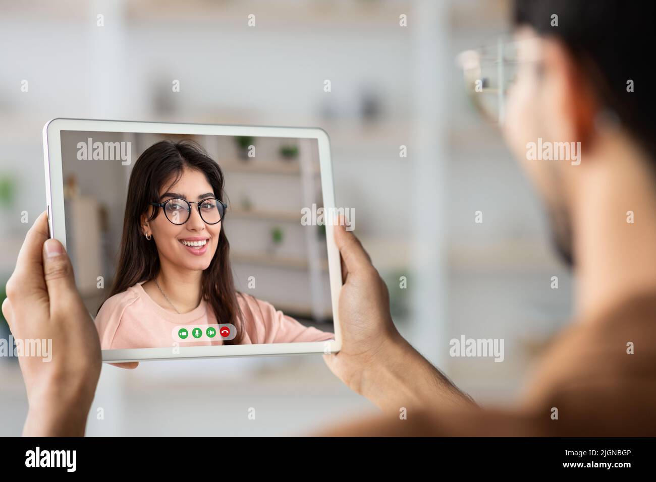 Young guy holding digital tablet and making video chat with his girlfriend Stock Photo