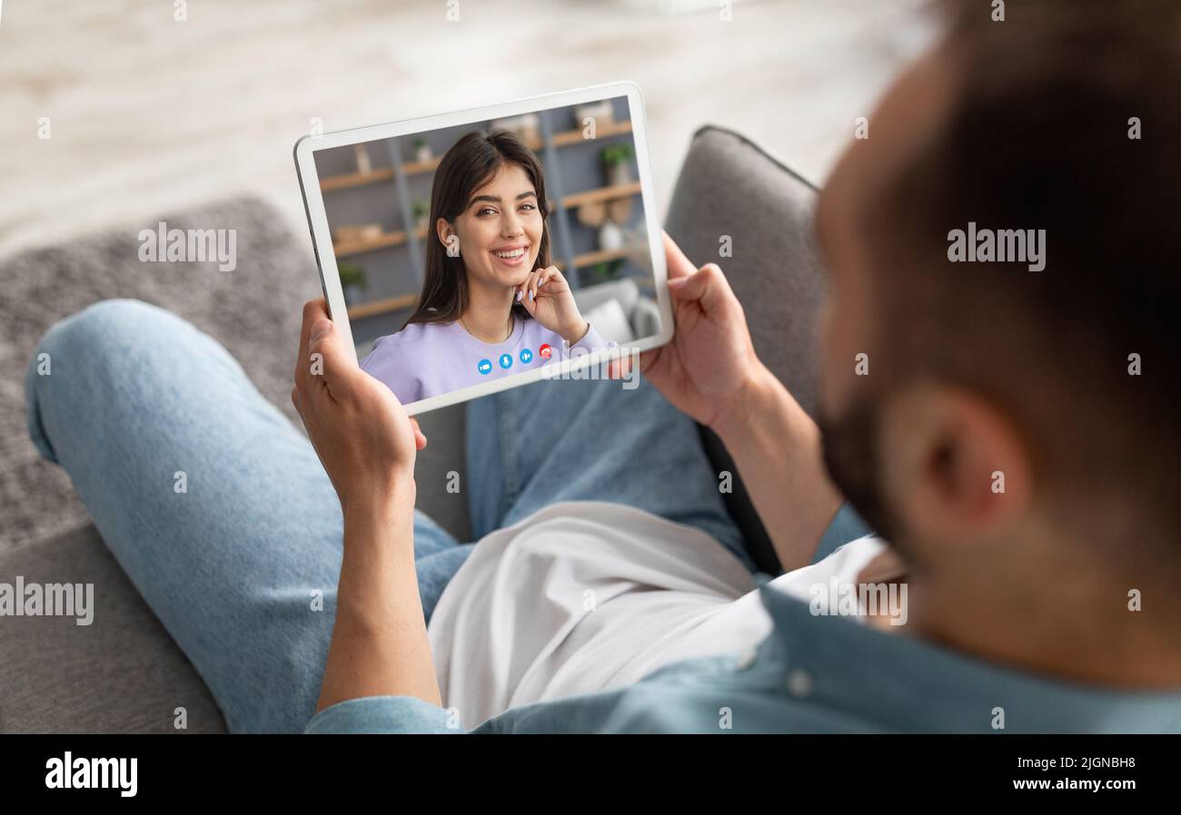 Young man using digital tablet at home for video chat with girlfriend Stock Photo