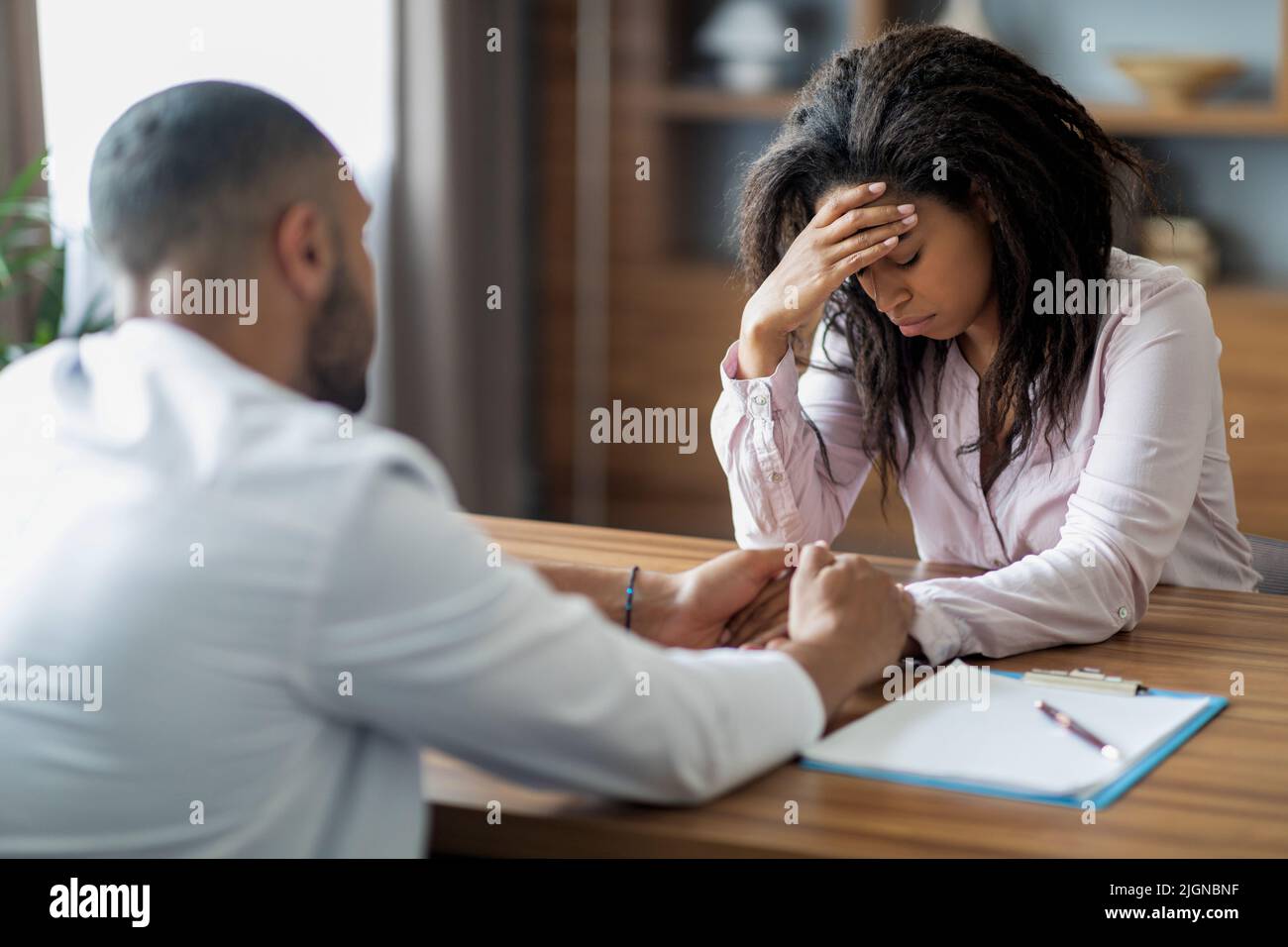 Male doctor having conversation with upset black woman patient Stock ...