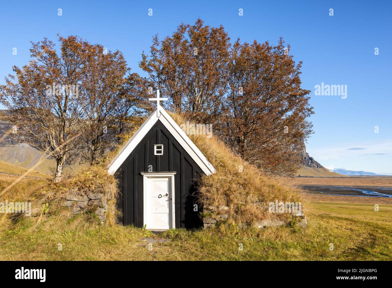 Old wooden black church in southern Iceland. Traditional style building with turf sides and roof, which helps to insulate in the cold winters. Autumn Stock Photo