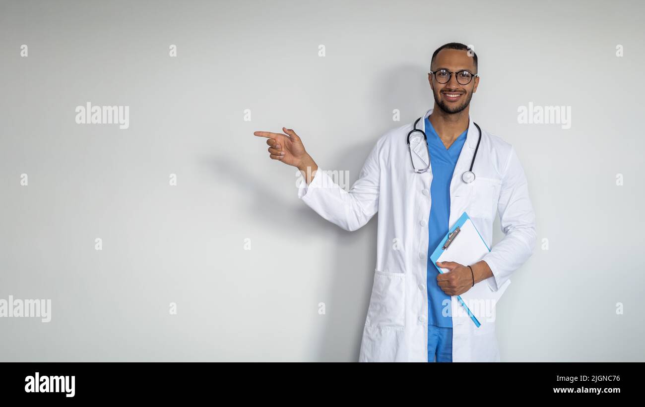 Smiling middle eastern doctor pointing at copy space Stock Photo