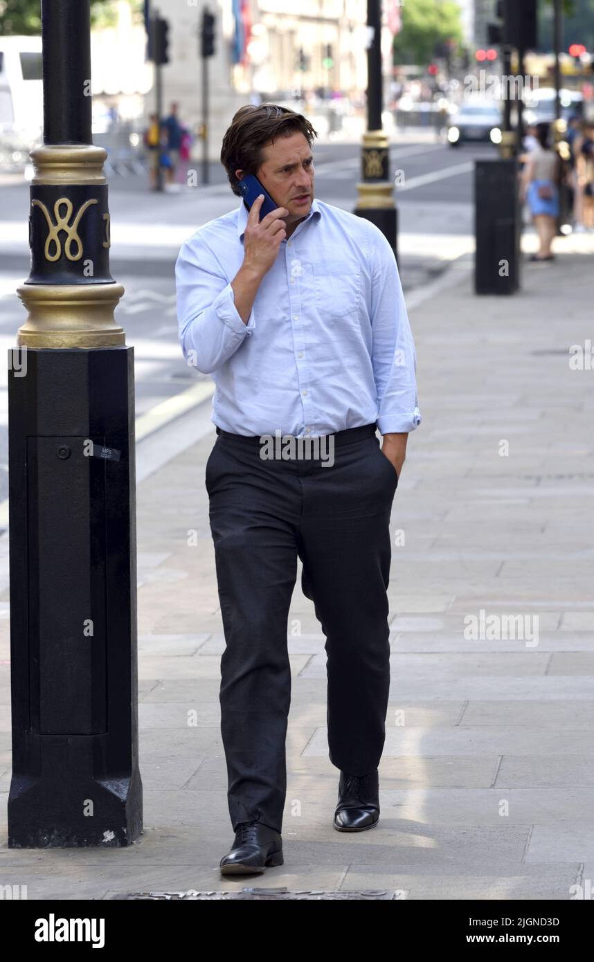 Johnny Mercer MP (Con: Plymouth Moor) - Minister for Veterans' Affairs - on his mobile phone outside the Cabinet Office in Whitehall, 11th July 2022 Stock Photo