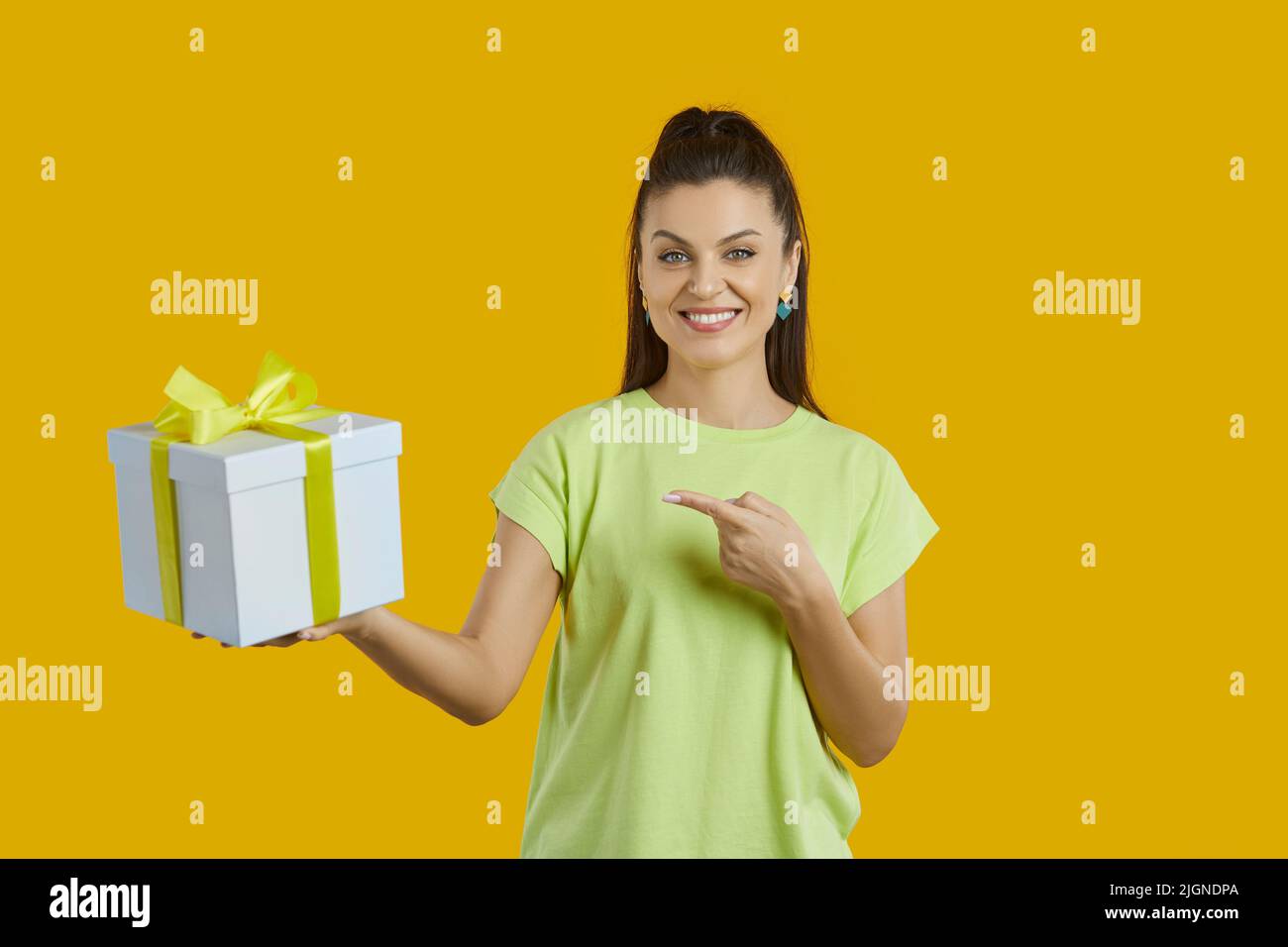 Smiling woman point at wrapped gift box Stock Photo