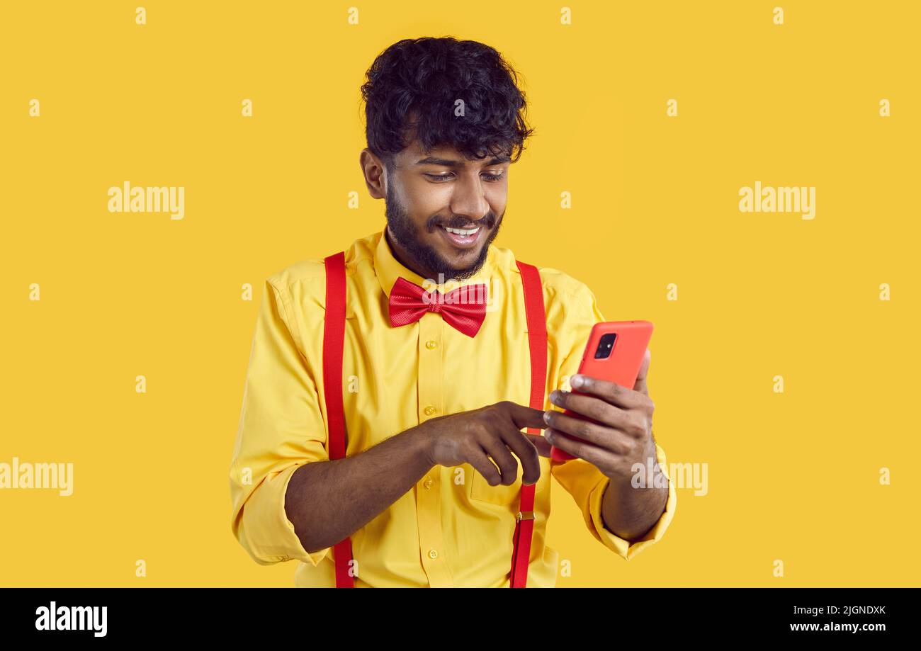 Smiling Indian man texting on cellphone Stock Photo