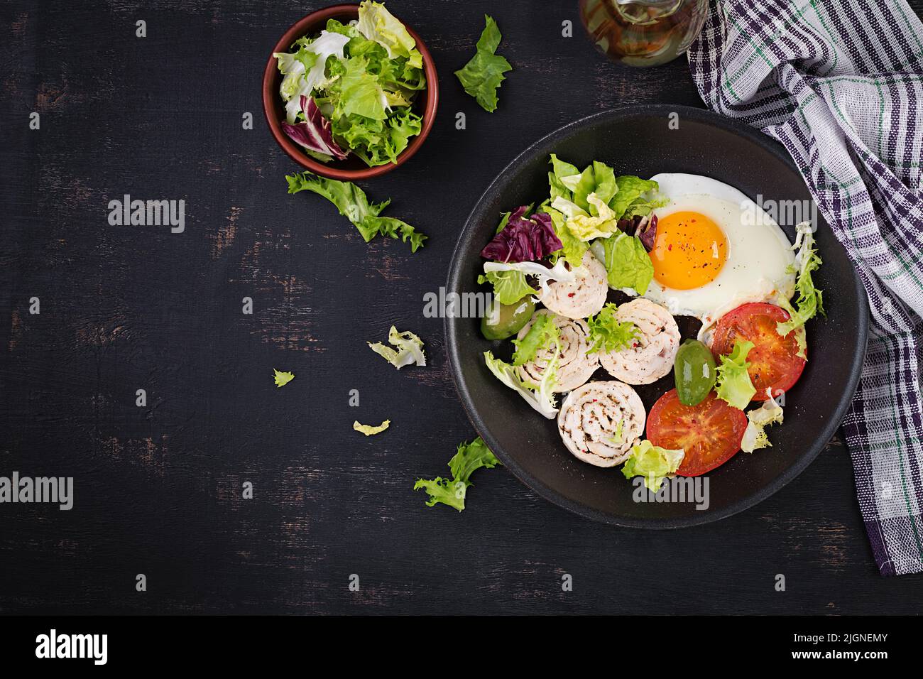Fried egg, meat roll, olives and tomatoes. Keto, paleo breakfast