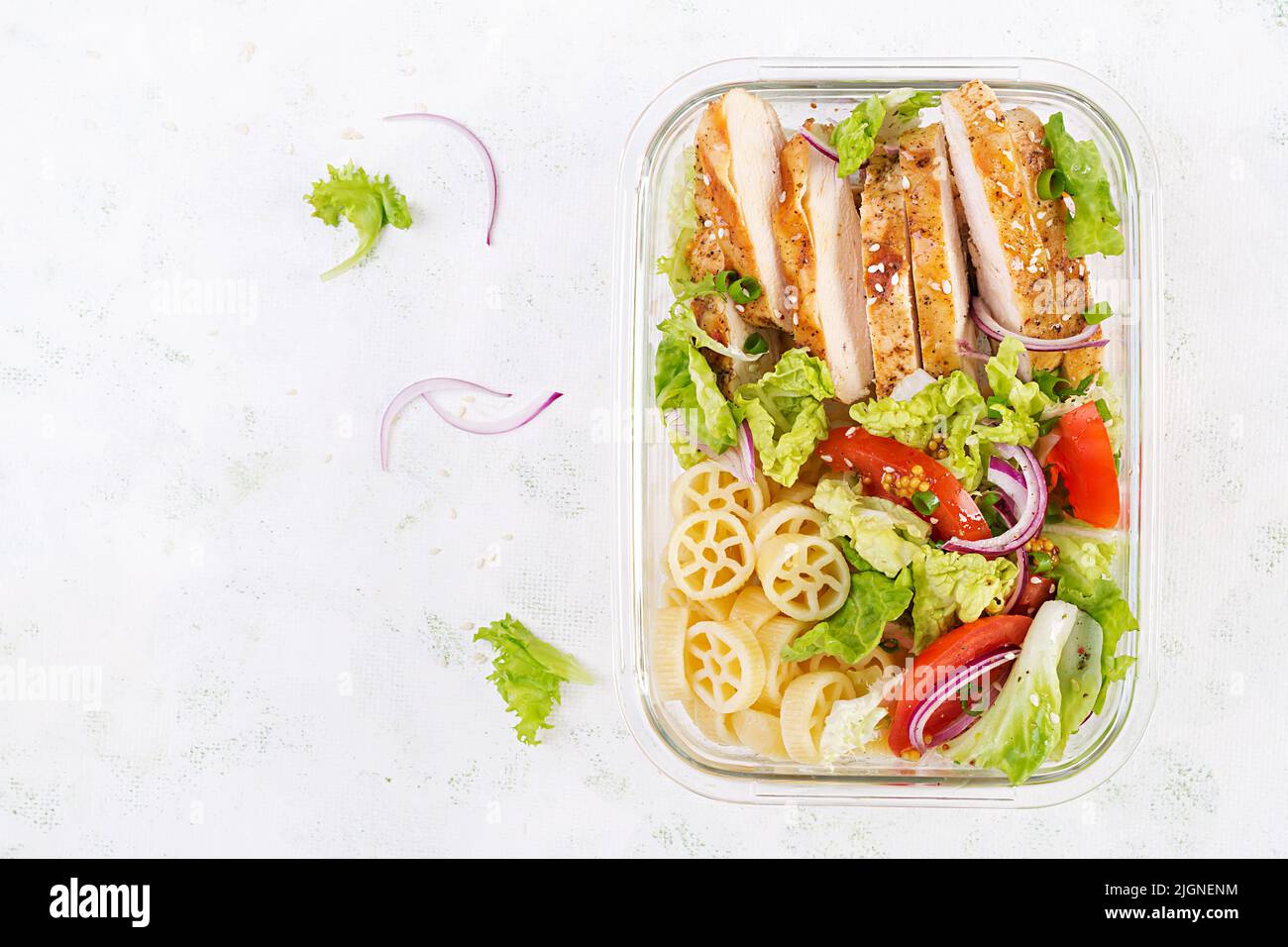 Lunchbox. Lunch box with grilled chicken fillet and pasta salad with fresh vegetables. Top view, overhead Stock Photo
