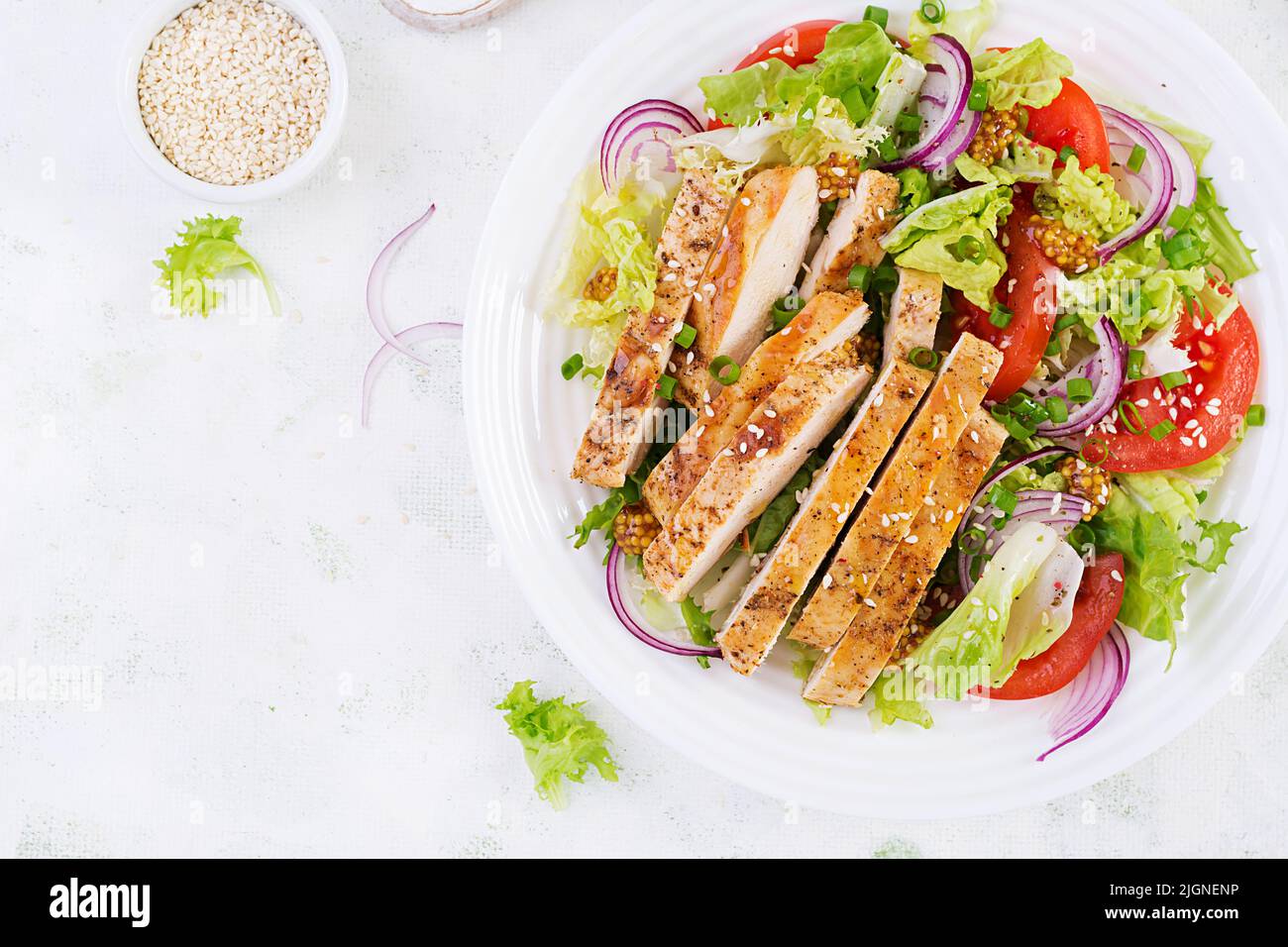 Salad with grilled chicken breast. Fresh vegetable salad with chicken meat. Healthy lunch menu. Diet food. Top view, flat lay Stock Photo