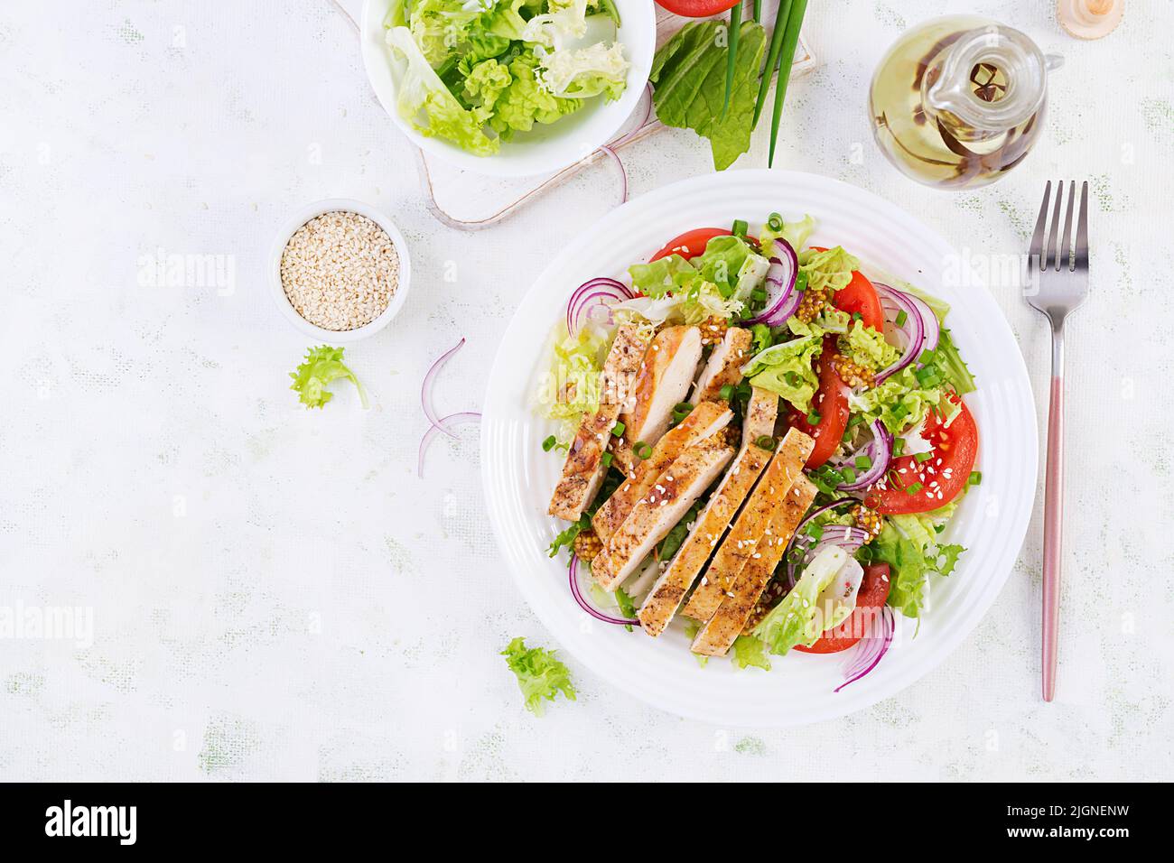 Salad with grilled chicken breast. Fresh vegetable salad with chicken meat. Healthy lunch menu. Diet food. Top view, flat lay Stock Photo