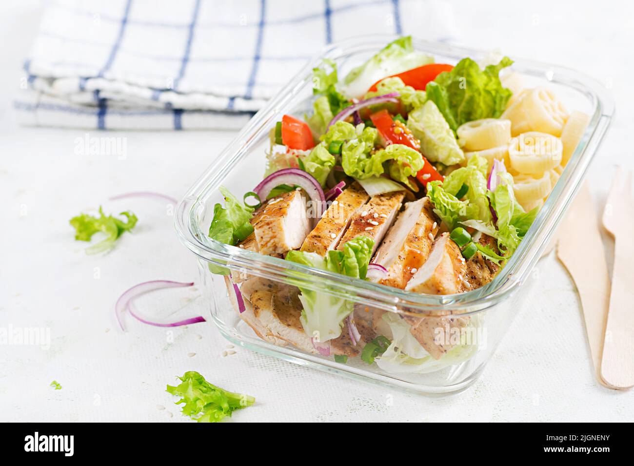 Lunchbox. Lunch box with grilled chicken fillet and pasta salad with fresh vegetables. Stock Photo