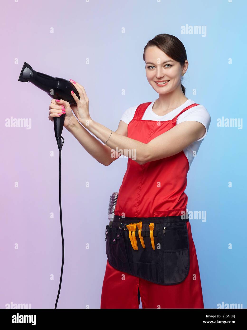 smiling hairdresser girl posing with hair dryer Stock Photo - Alamy