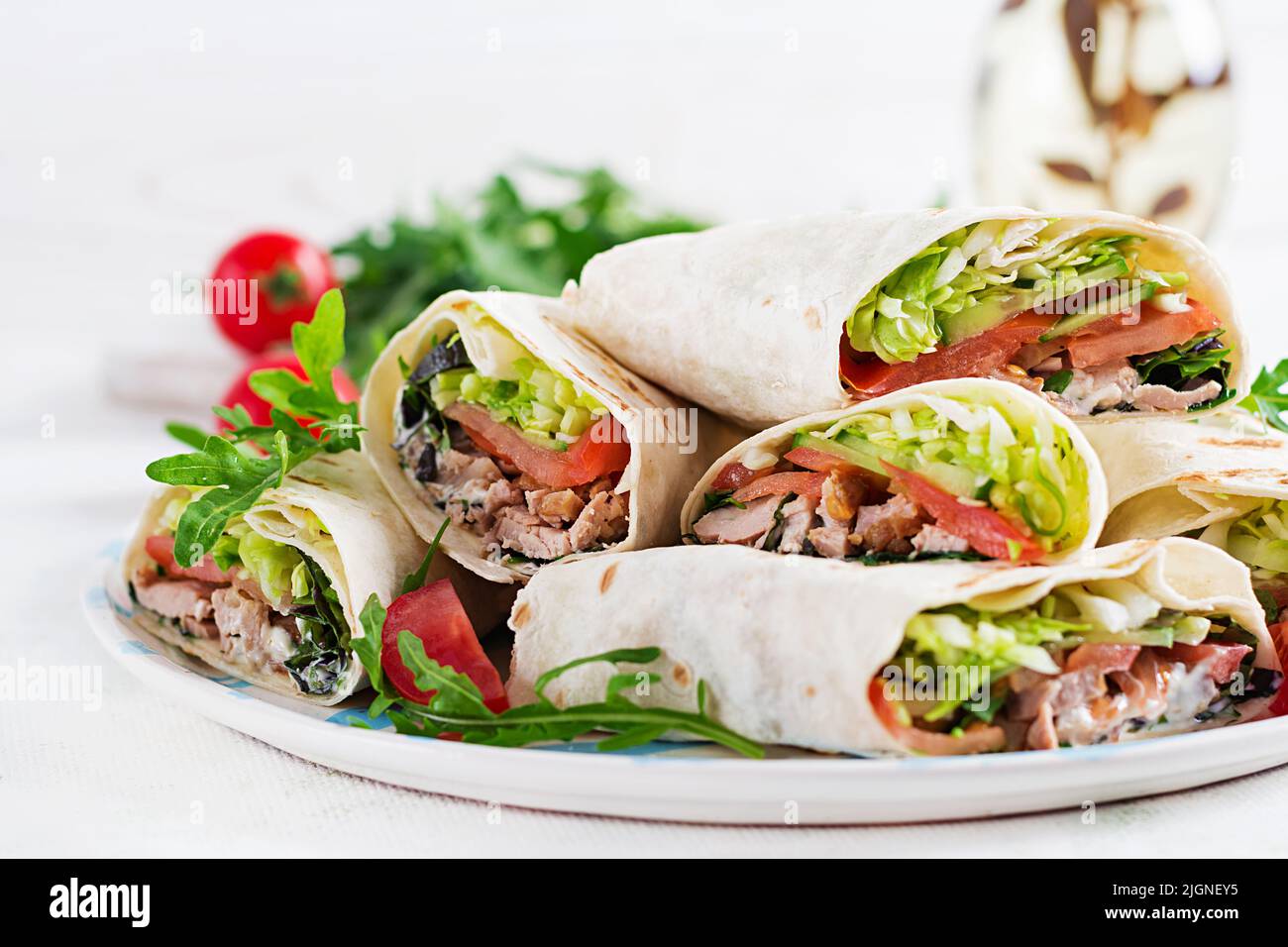 Burritos wraps with beef and vegetables on light  background. Beef tortilla, mexican food. Stock Photo
