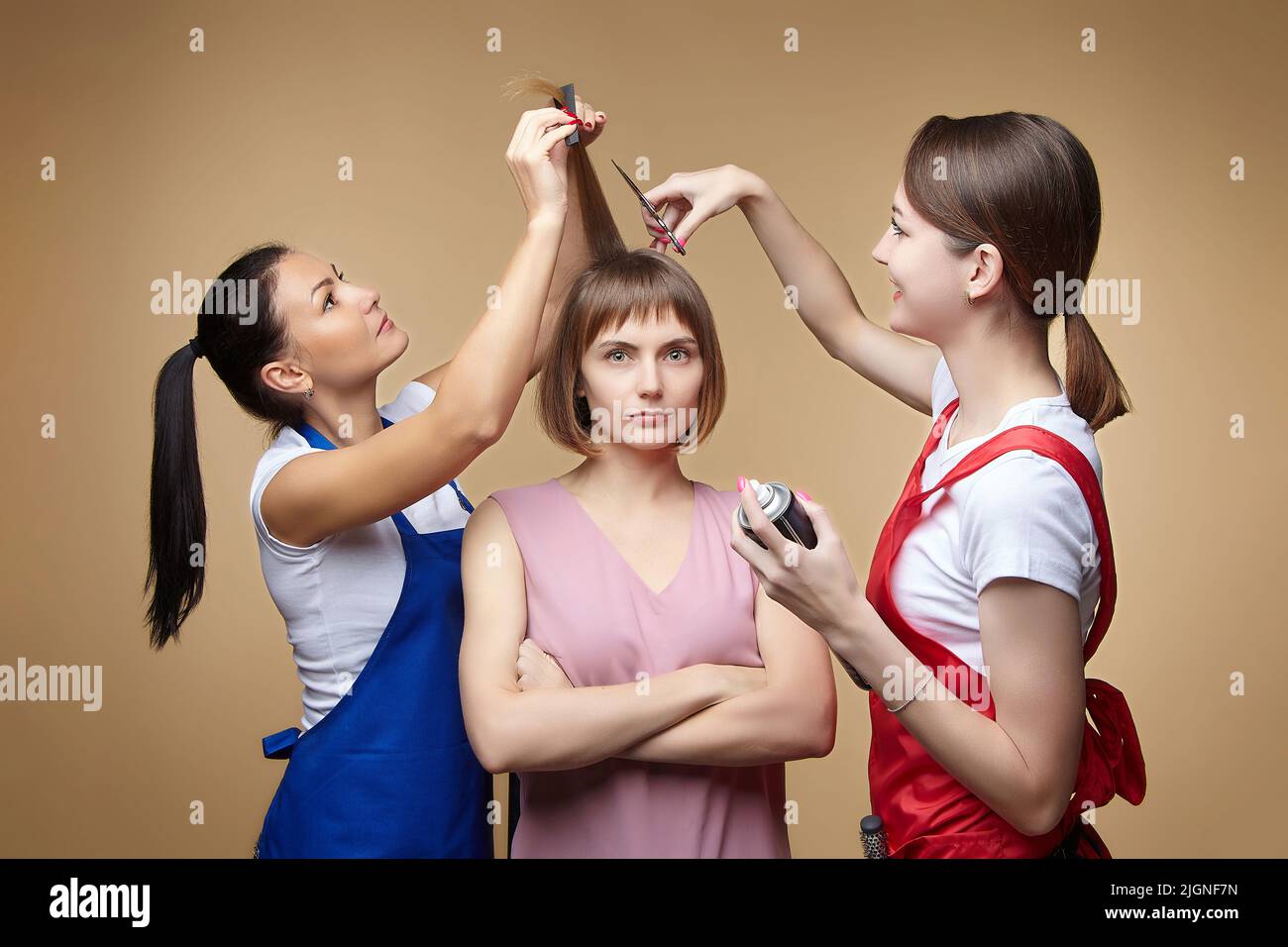 two hairdressers cut a young girl's hair. photo shoot in the Studio