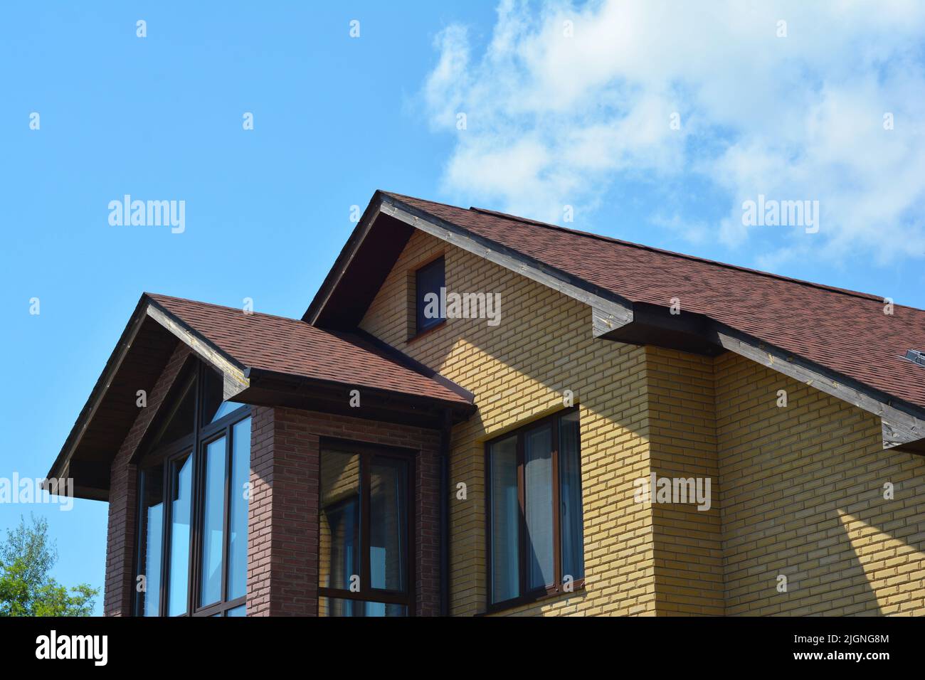 Brick house rooftop with panoramic window and asphalt shingled roof