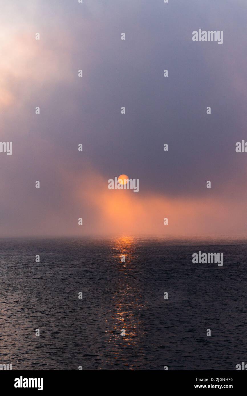 Sunrise over a misty ocean Stock Photo