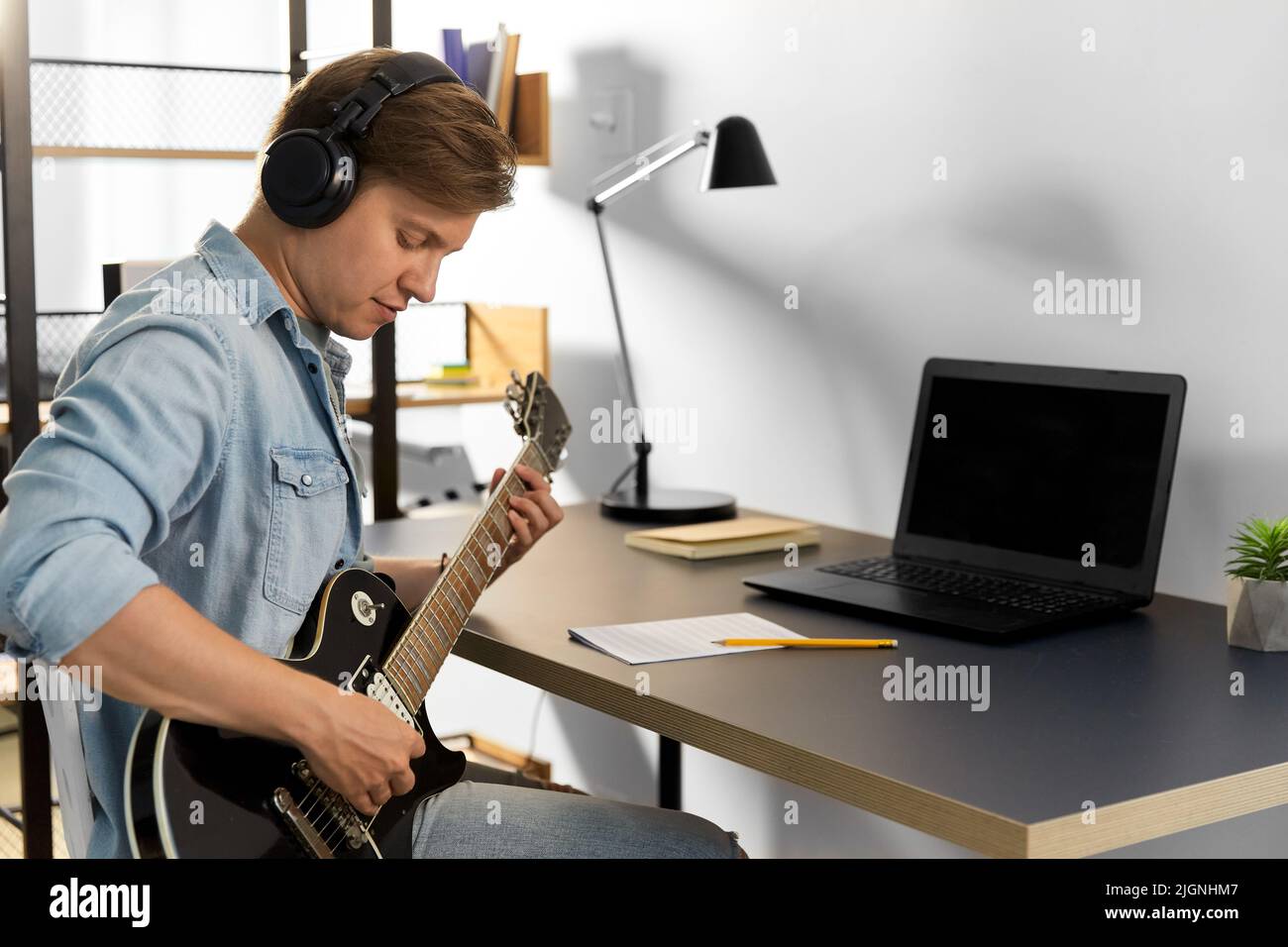 man in headphones playing bass guitar at home Stock Photo Alamy