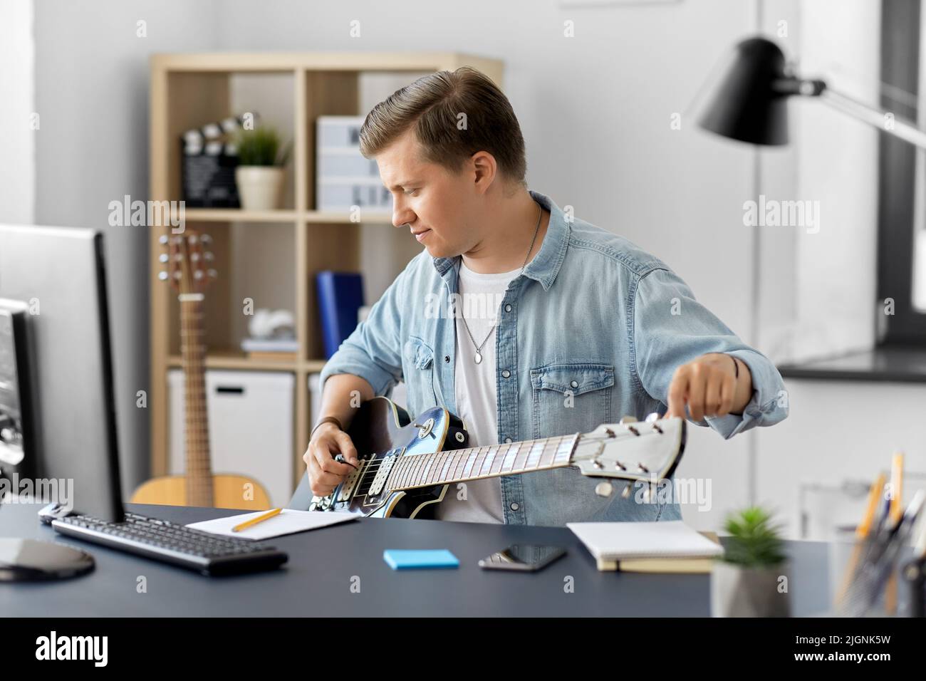 Young guy playing guitar home hi-res stock photography and images - Alamy