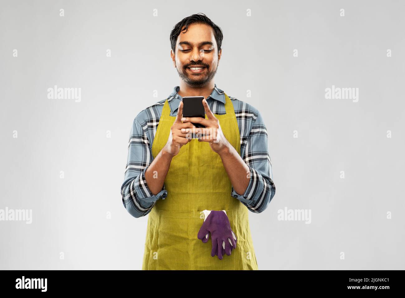 indian male gardener or farmer with smartphone Stock Photo