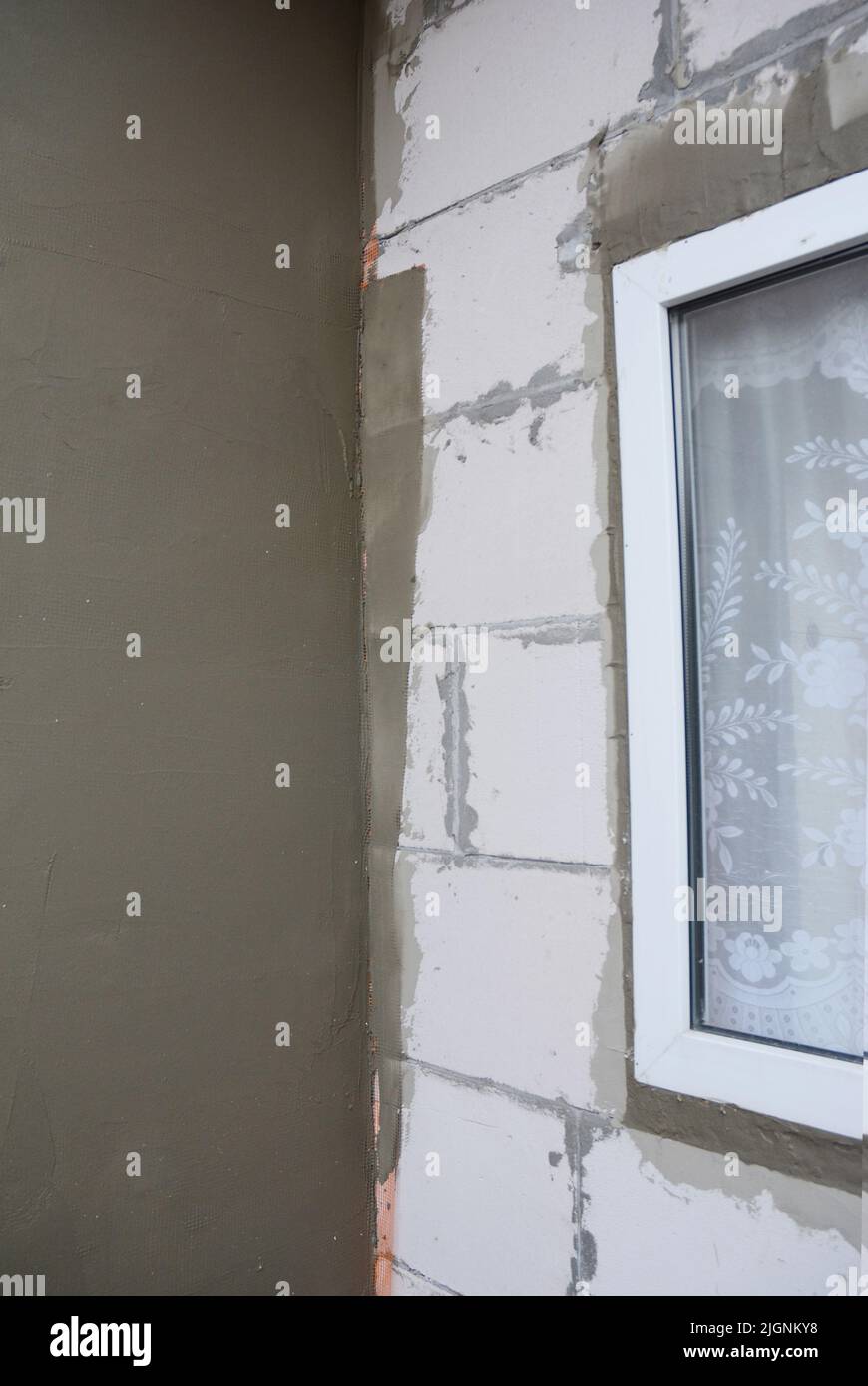 Unfinished house corner plastering wall with fiberglass mesh, plaster