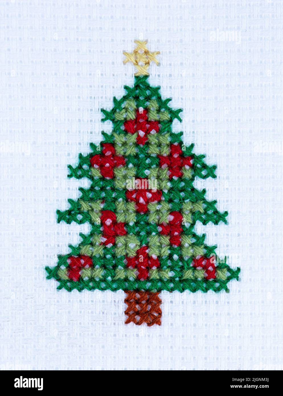 Close up of a simple cross stitch pattern of a colourful Christmas Tree with copy space Stock Photo