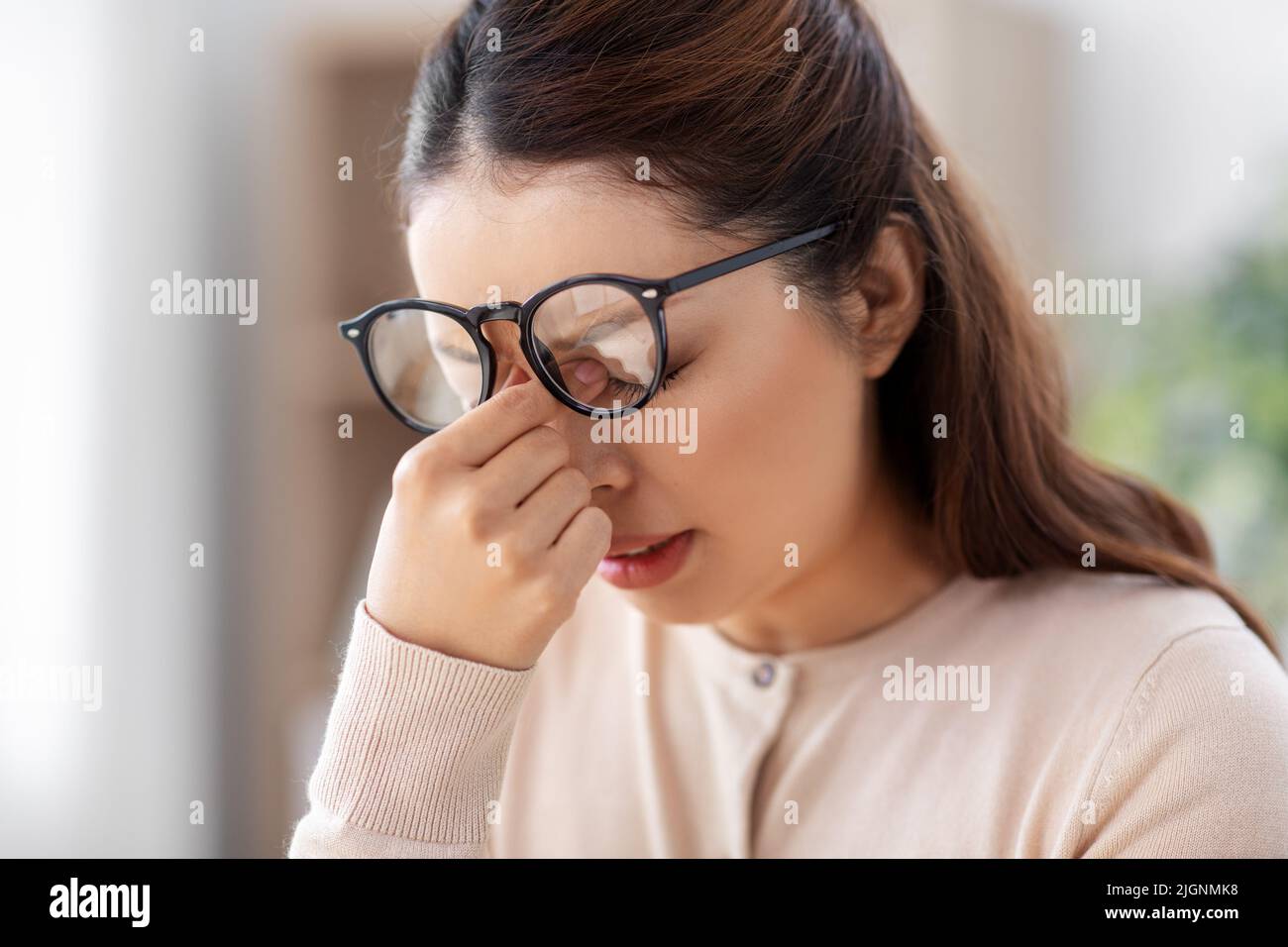 tired woman with glasses rubbing her nose bridge Stock Photo Alamy