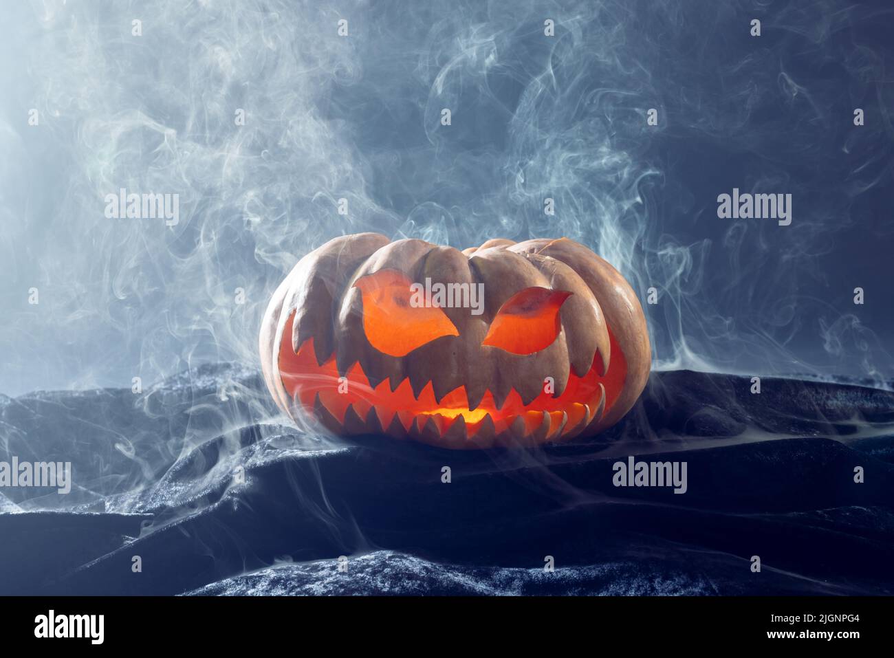 Composition of halloween carved pumpkin with smoke on black background ...