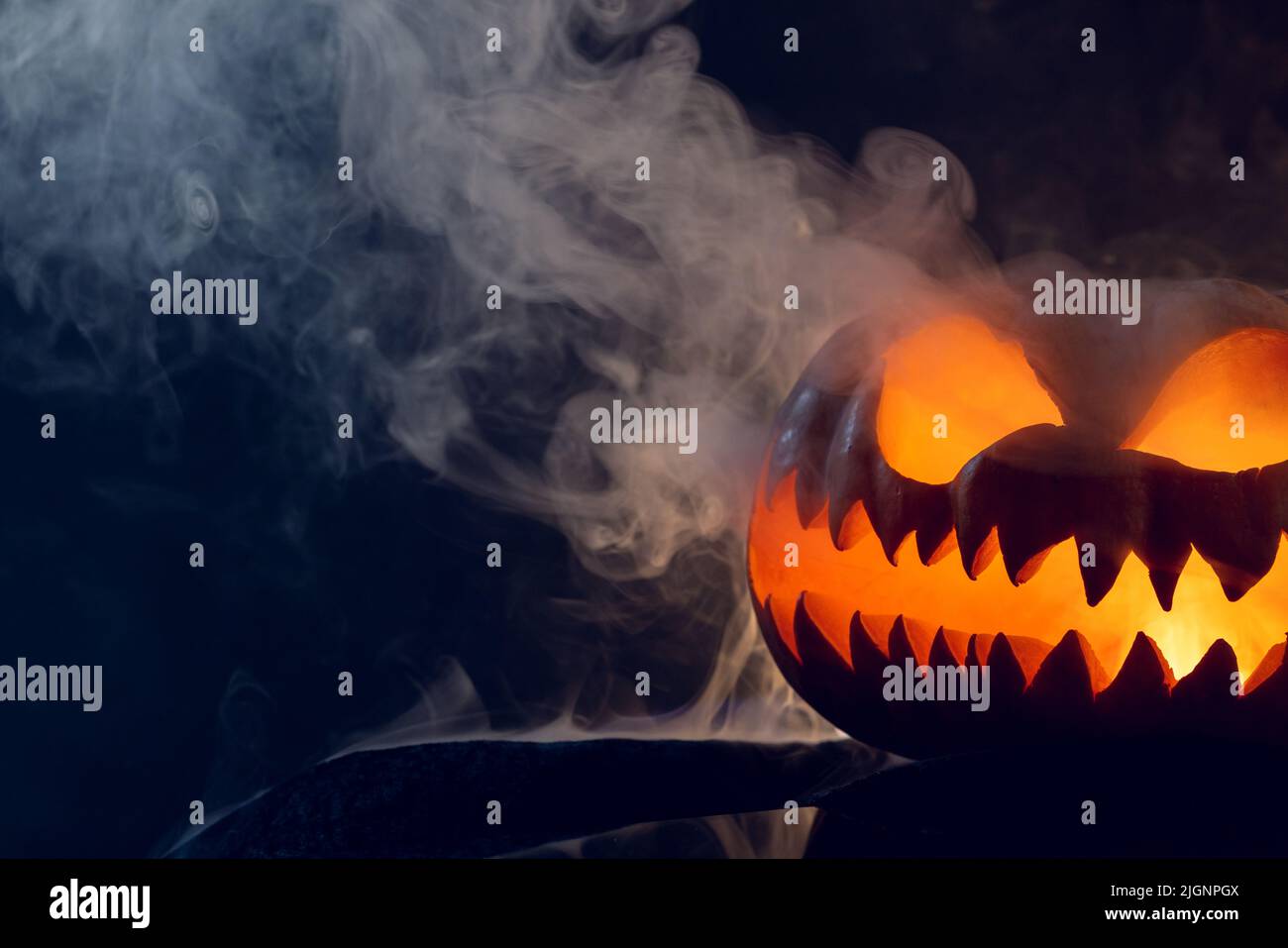Composition of halloween carved pumpkin with smoke on black background ...