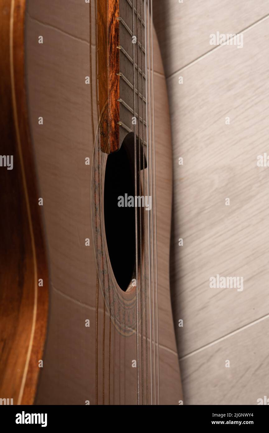 Classical guitar sound hole and strings up close on a light wood