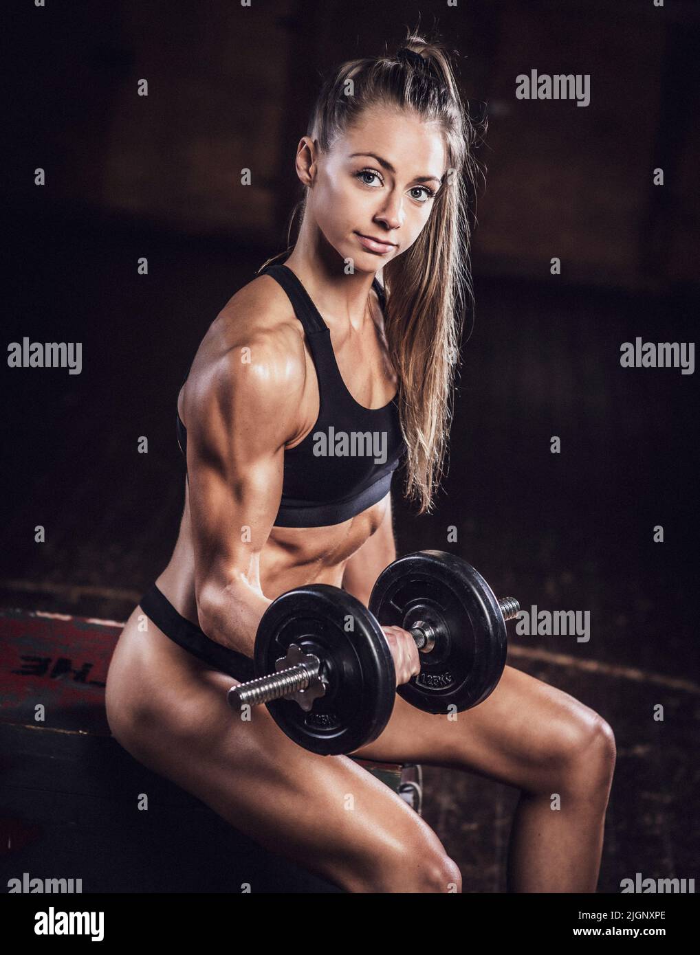 Female fitness model with toned body working out with weights, UK Stock Photo