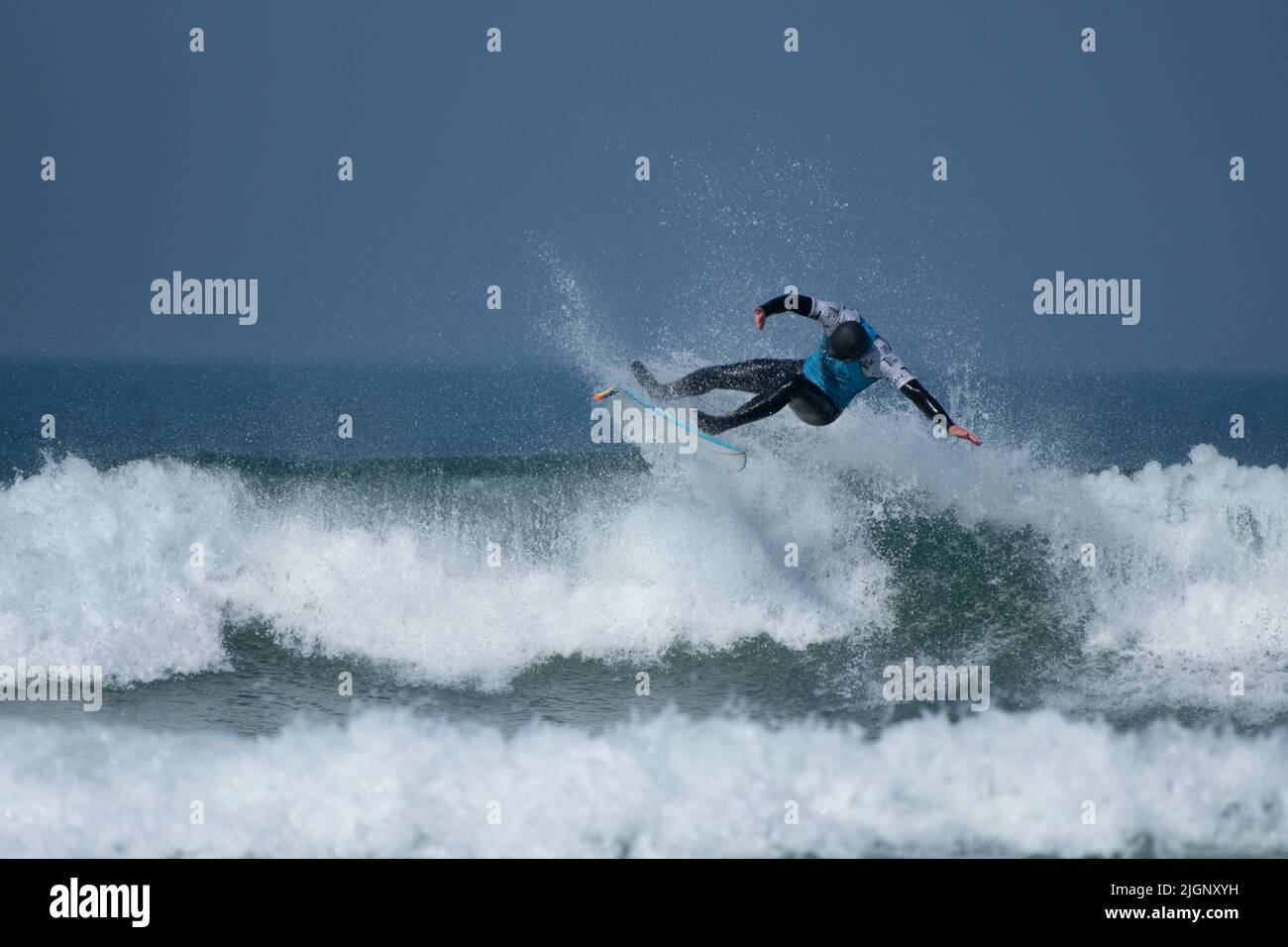 A male surfer competing in a surfing competition at Fistral in Newquay in Cornwall in the UK. Stock Photo