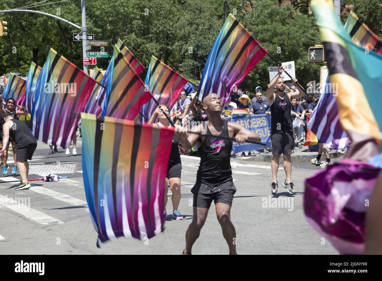 The annual Gay Pride Parade returns to march down 5th Avenue  and end up on Christopher Street in Greenwich Village after a 3 year break due to the Covid-19 pandemic. Group of flag dancers crossing 6th Ave, to Christopher Street. Stock Photo