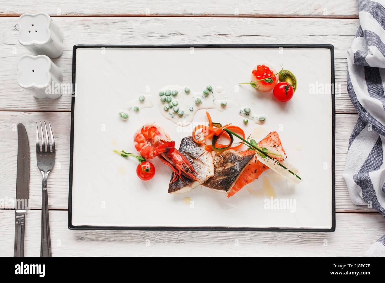 Seafood mix on white plate with cutlery flat lay Stock Photo - Alamy