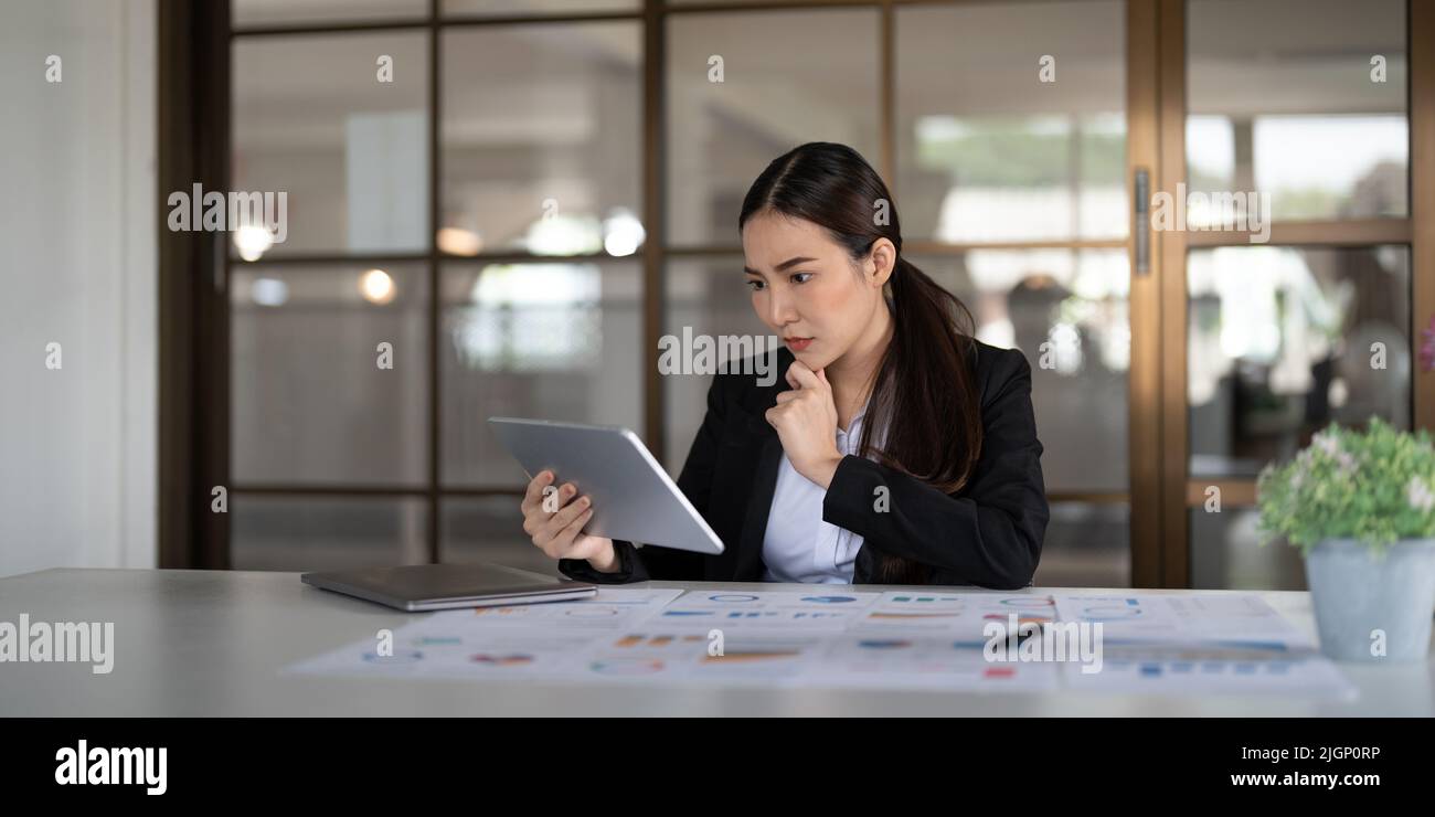 Portrait seriously business asian woman using digital tablet for do ...