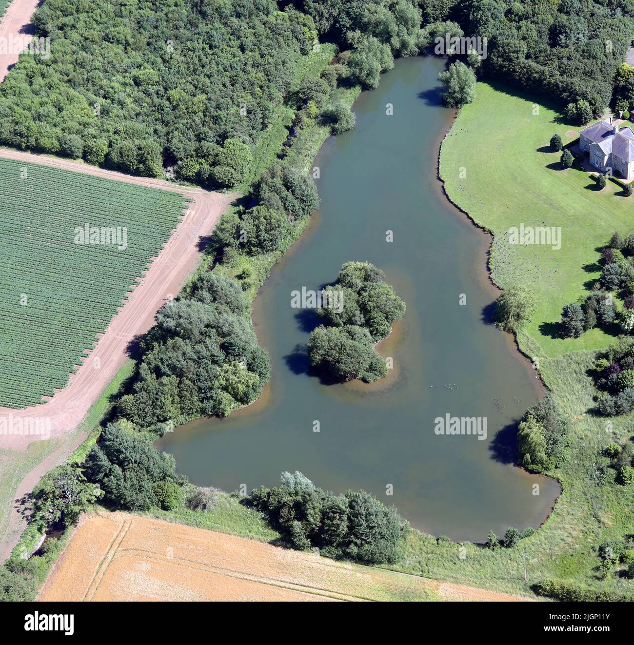 Aerial view of a private lake similar to the shape of England. Melsonby, North Yorkshire. Stock Photo