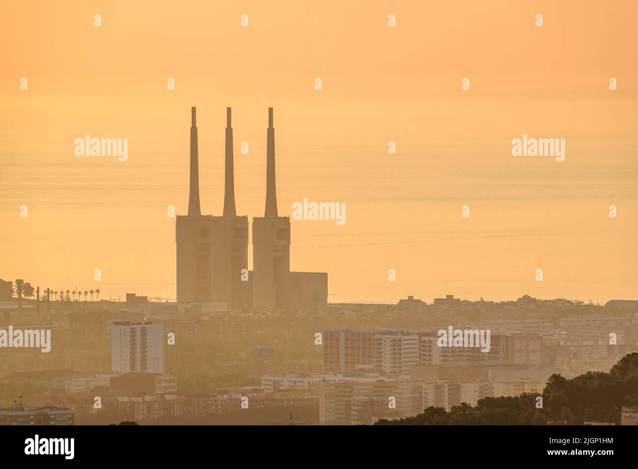 Sunrise over Barcelona region seen from the Tibidabo mountain. In the background, the Sant Adrià de Besòs Thermal power station (Barcelona, Spain) Stock Photo