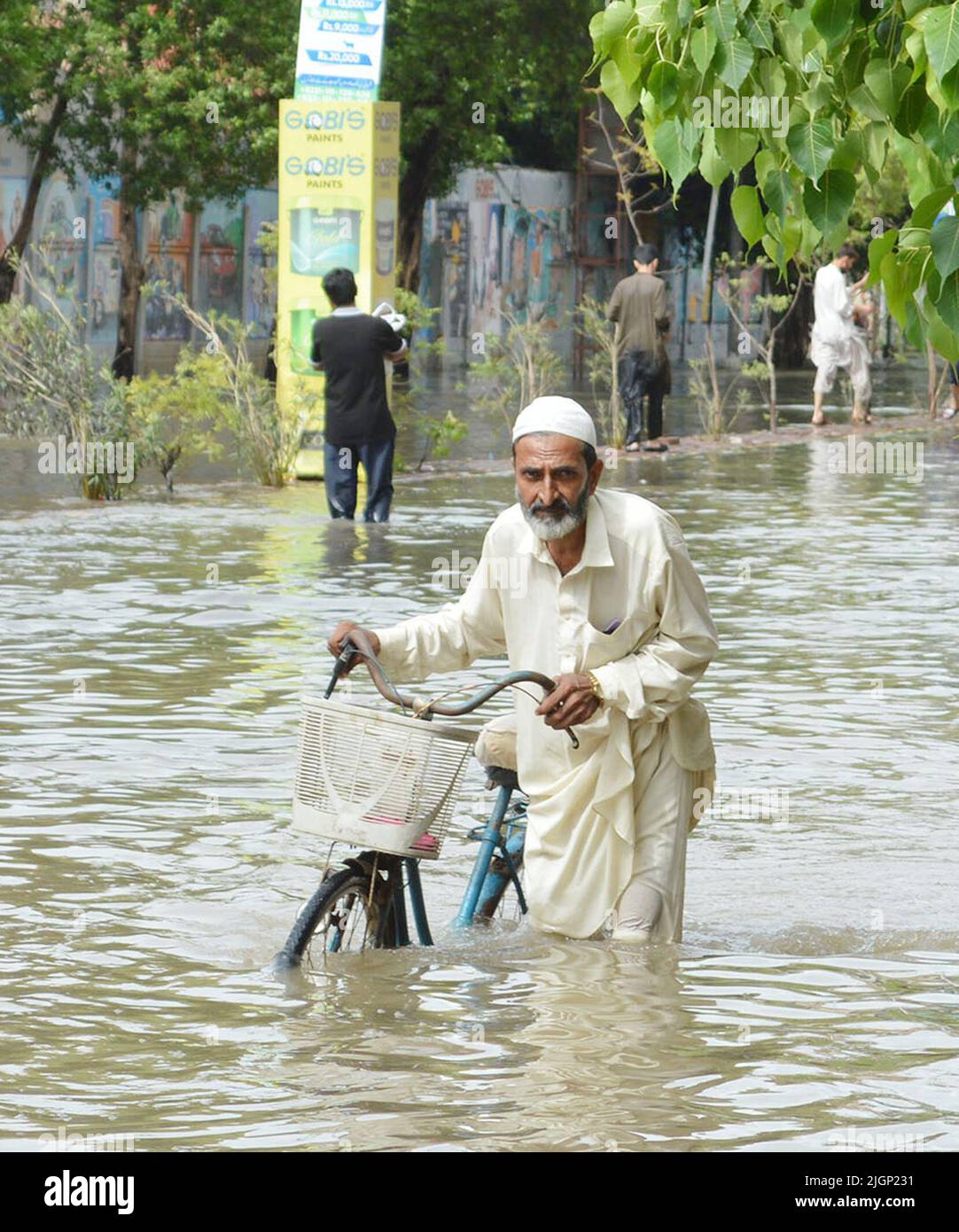 Karachi. 11th July, 2022. A man wades through a flooded road after heavy monsoon rain in southern Pakistani port city of Karachi on July 11, 2022. The death toll in Karachi from the latest spell of monsoon rains which started last week went up to around 20 by Monday night, rescue workers and local media reported. Credit: Str/Xinhua/Alamy Live News Stock Photo