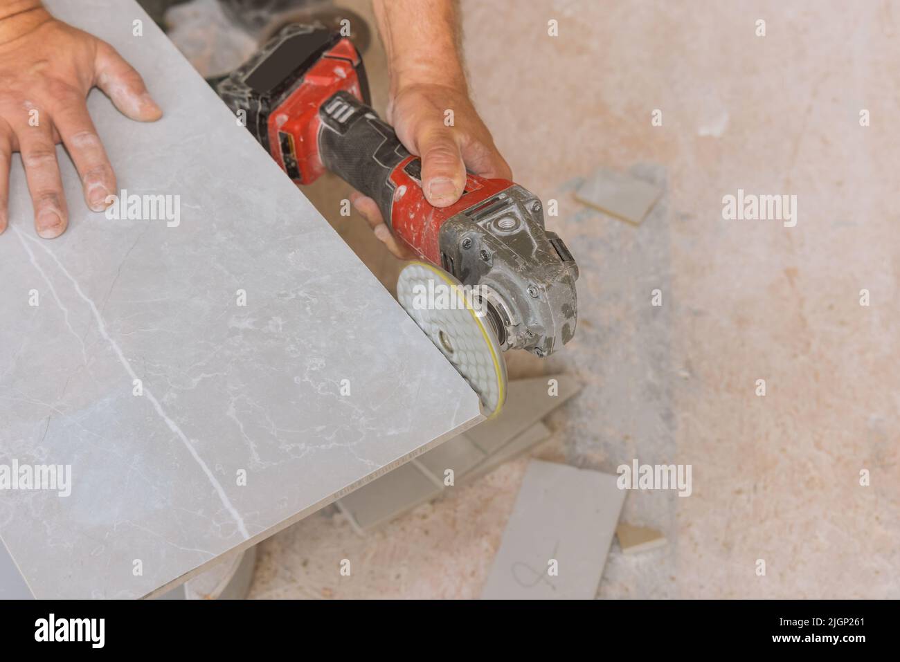 Using an angle grinder polishing disk with diamond for polishing the corner edges of tiles cut Stock Photo
