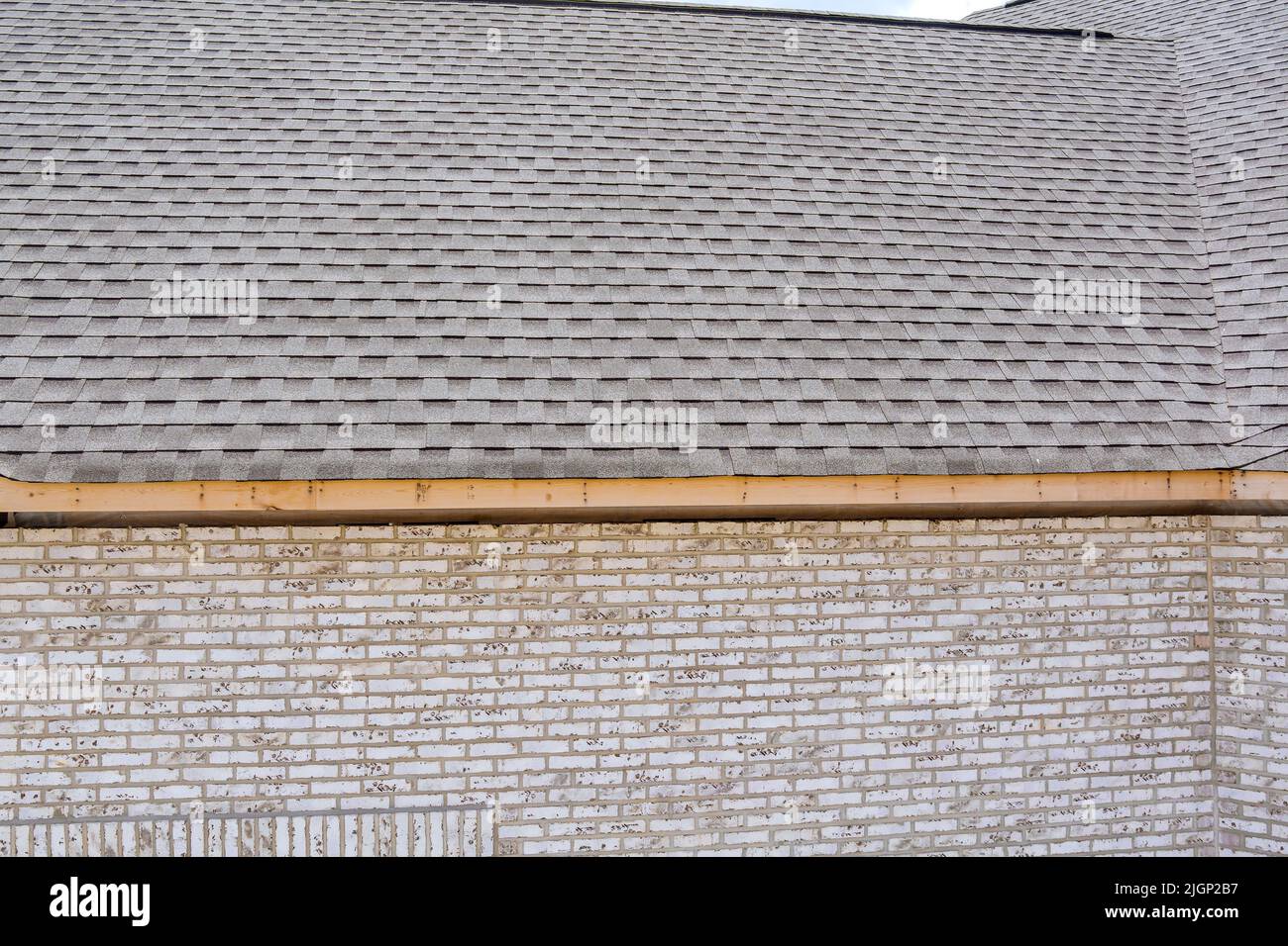 Building construction working on a new roof covering asphalt shingles