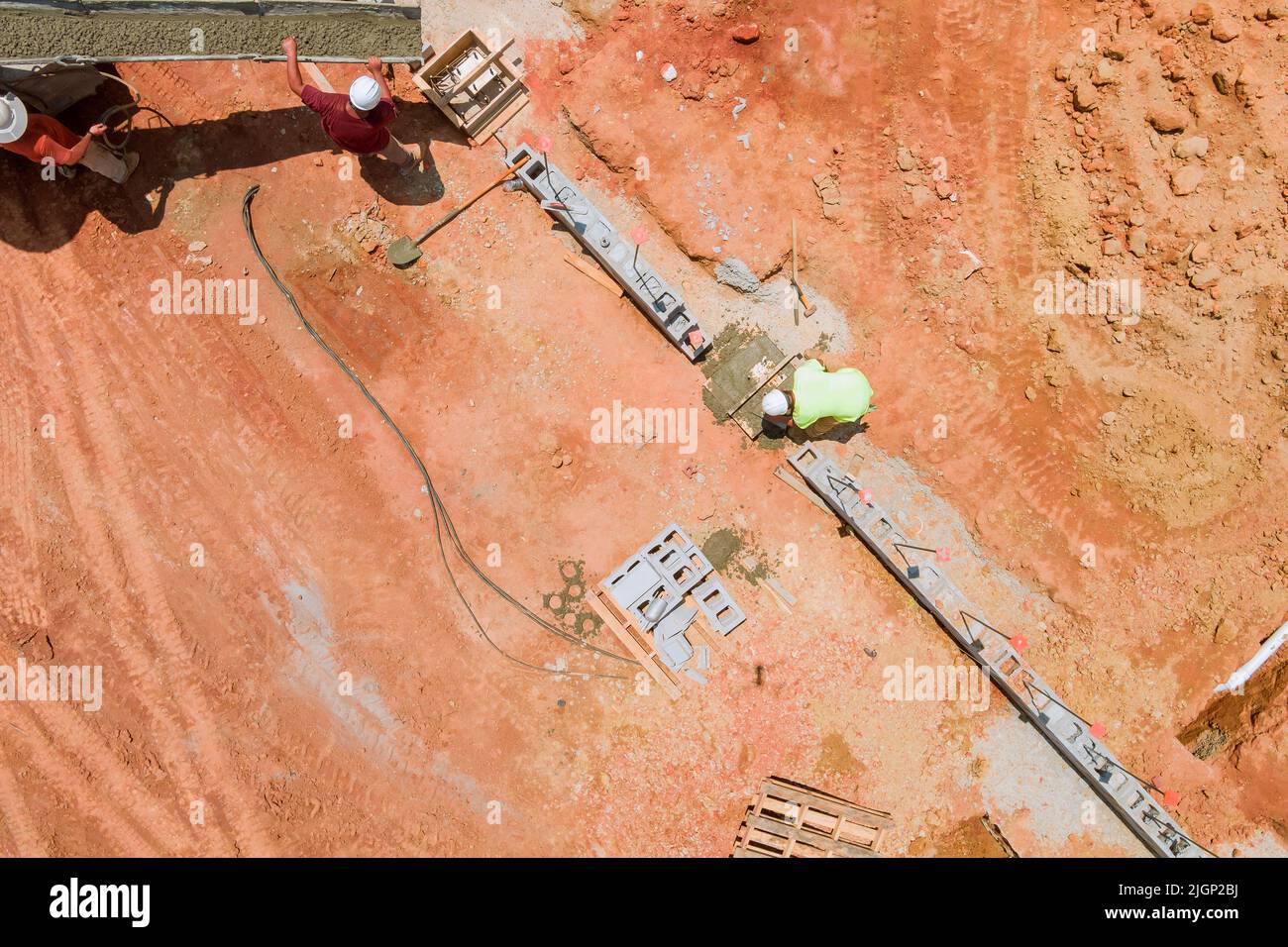 In an aerial view, workers pour concrete columns on a construction site Stock Photo