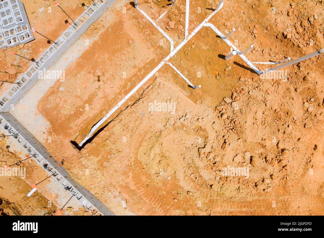 Installing sewer and water pipes in the ground under the foundation of a new residential construction home Stock Photo