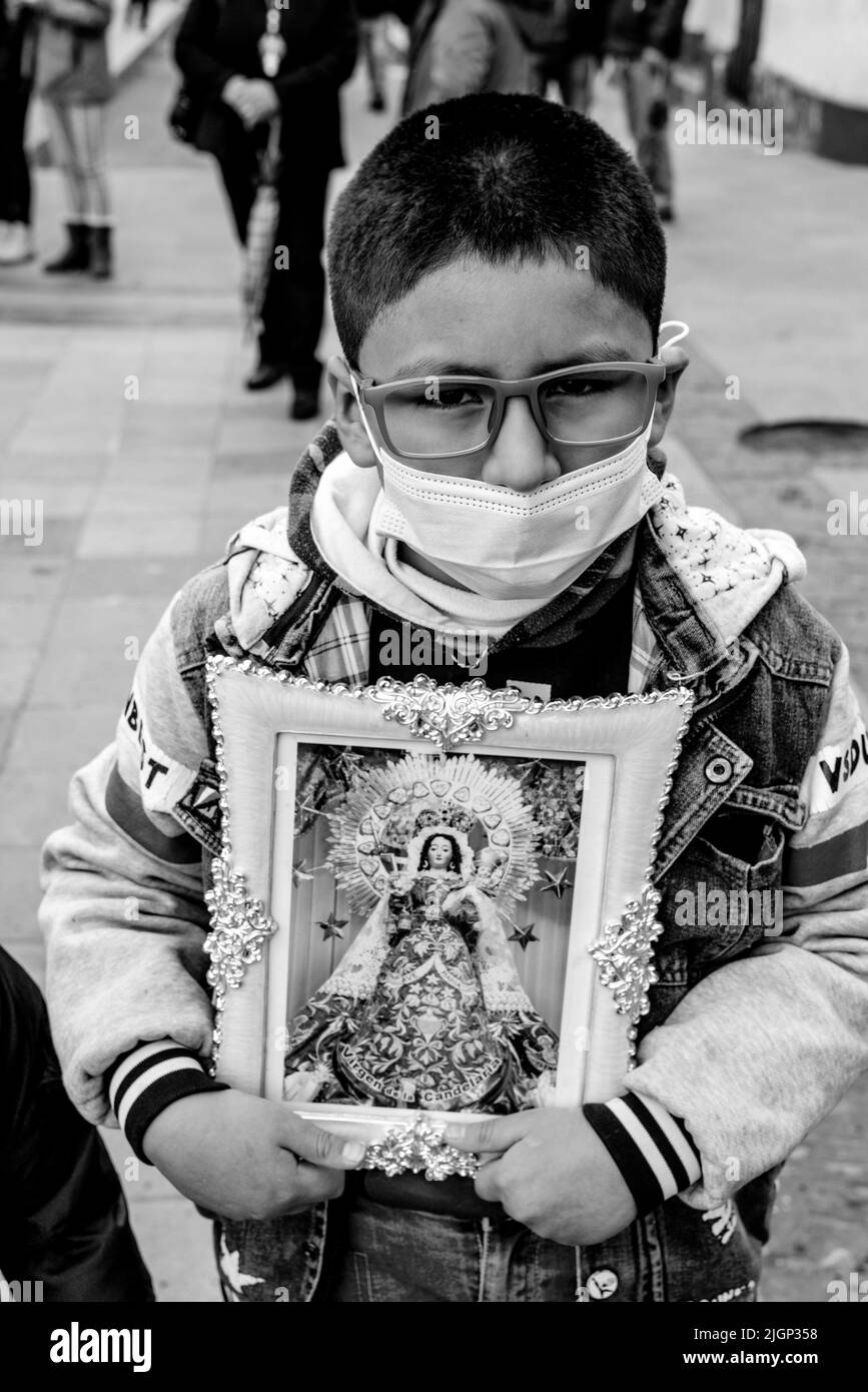 A Young Boy Holds Up An Image Of The Virgin Mary During A Religious Festival, Plaza De Armas, Puno, Puno Province, Peru. Stock Photo