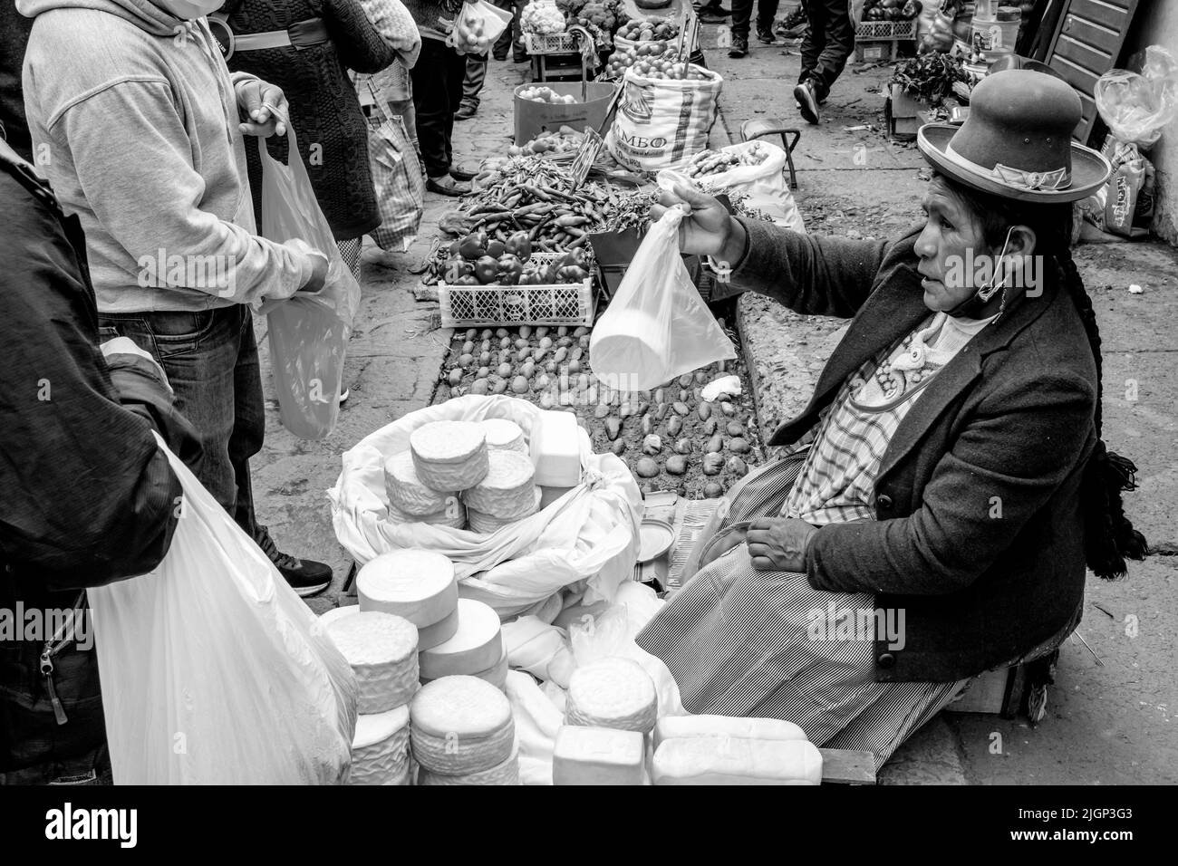 An Indigenous Woman Selling Fresh Cheese At A Street Market In Cusco, Cusco Province, Peru. Stock Photo