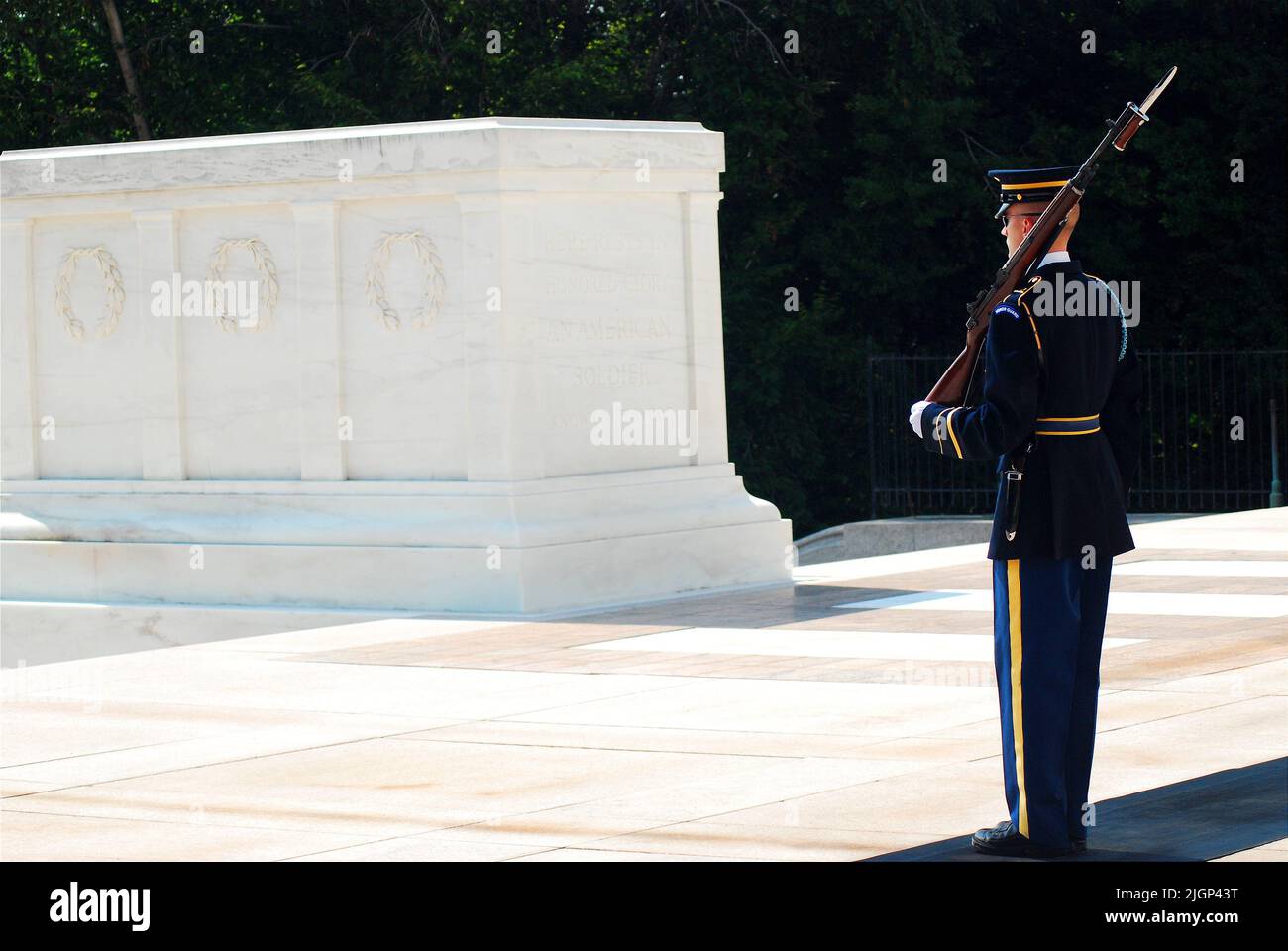 A soldier stands at attention and guards the Tomb of the Unknown Soldiers in  Arlington National Cemetery near Washington DC Stock Photo