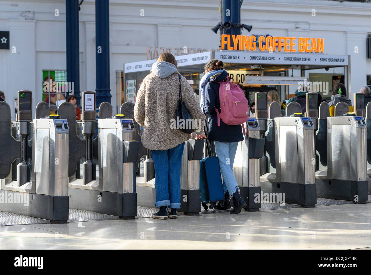 Passengers passing through ticket barriers at Brighton Railway Station, England. Stock Photo