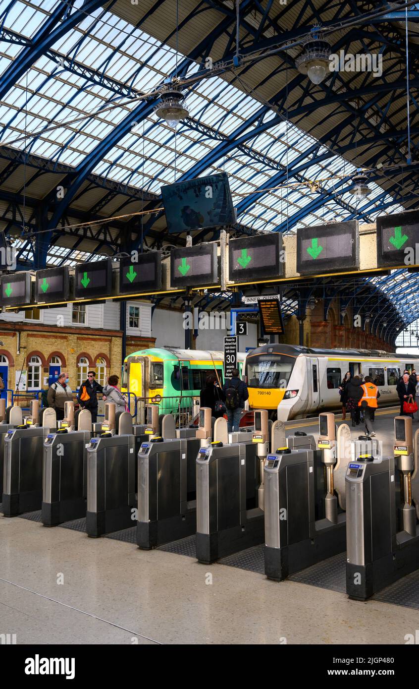 Passengers passing through ticket barriers at Brighton Railway Station, England. Stock Photo