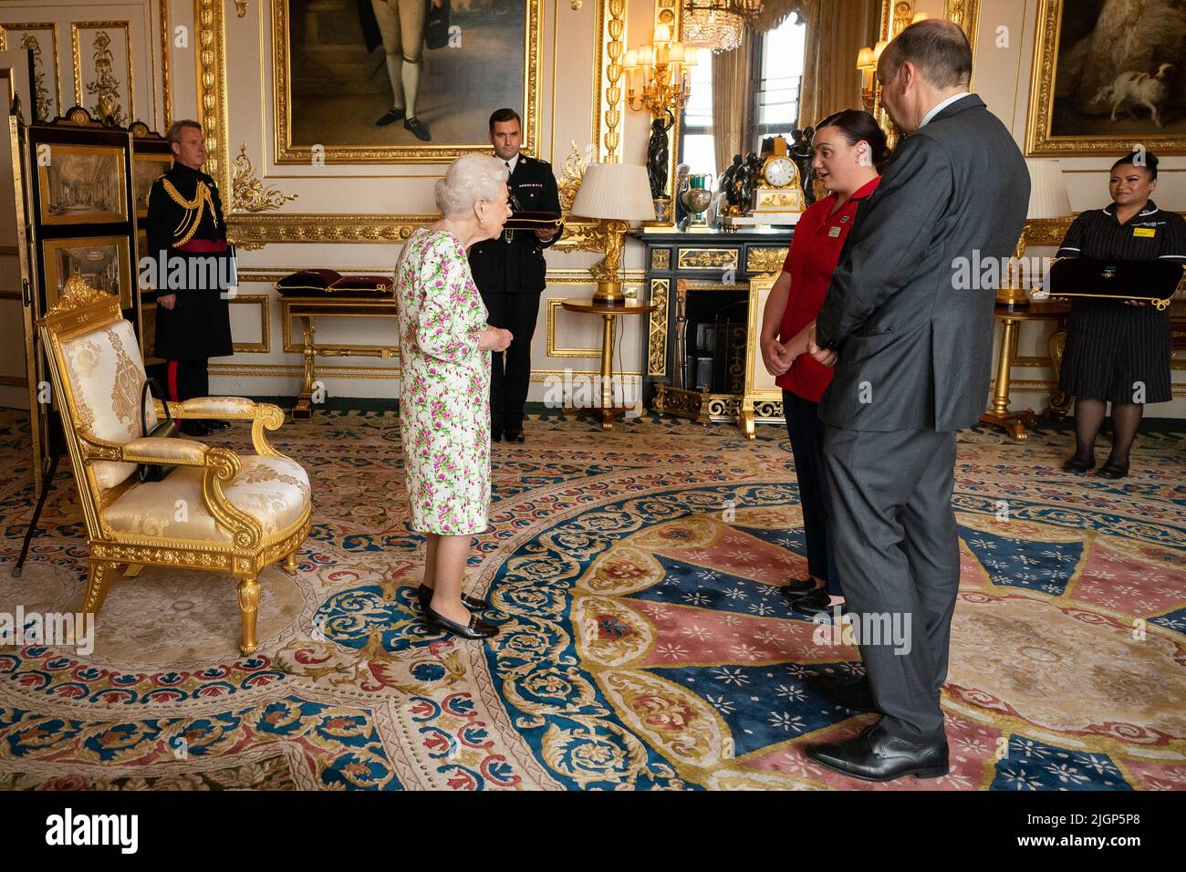 Queen Elizabeth II presenting the George Cross to representatives of the National Health Service Mr Peter May, Permanent Secretary at the Department of Health and Chief Executive of Health and Social care, and Sister Joanna Hogg, Royal Victoria Hospital Emergency Department, during an Audience at Windsor Castle, Berkshire. Picture date: Tuesday July 12, 2022. Stock Photo
