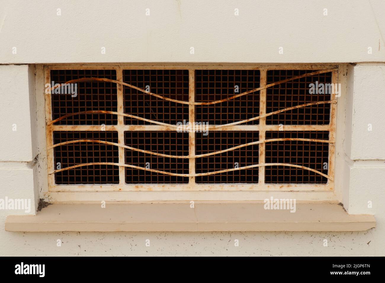 Rusty old window on the side of a building Stock Photo