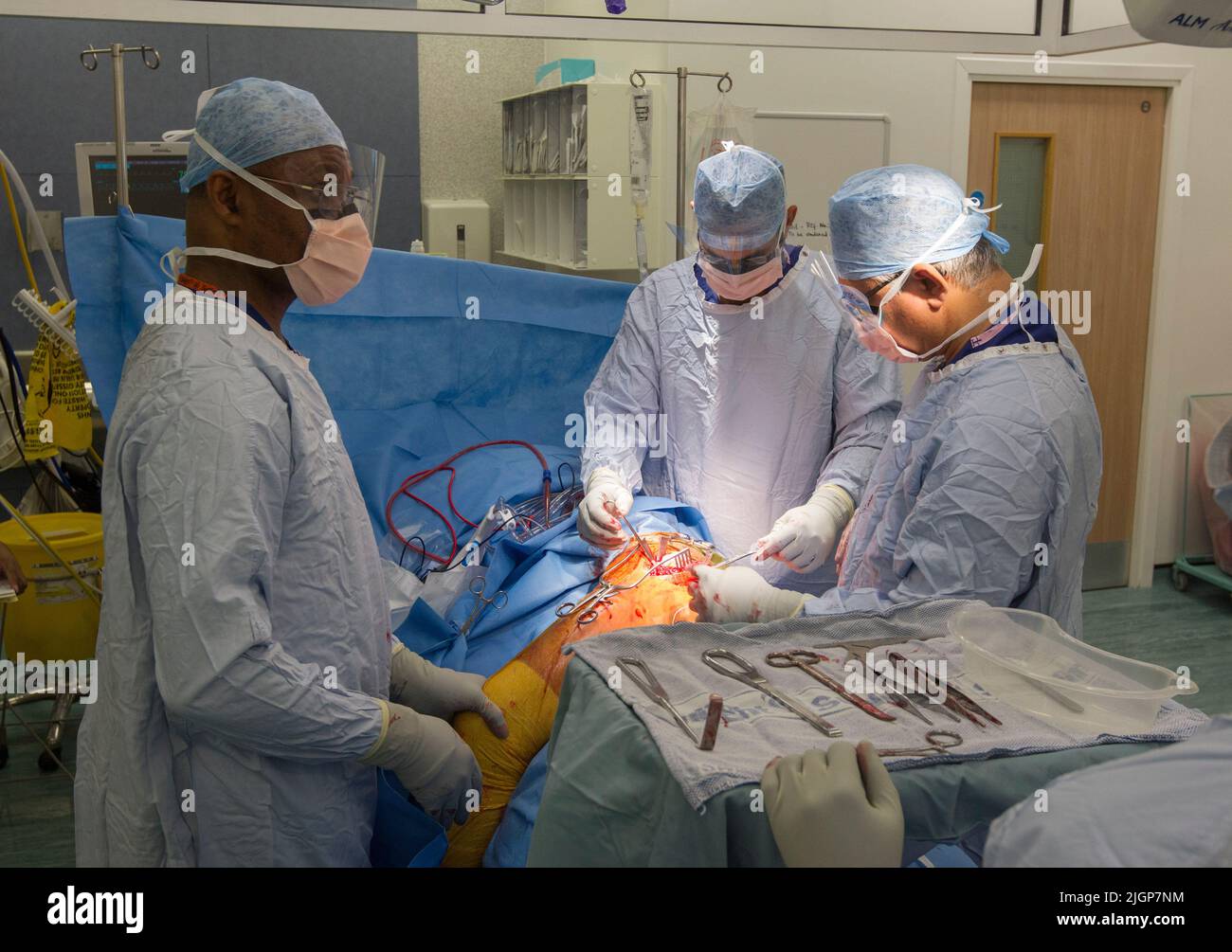 A surgeon and NHS staff perform knee surgery, also known as