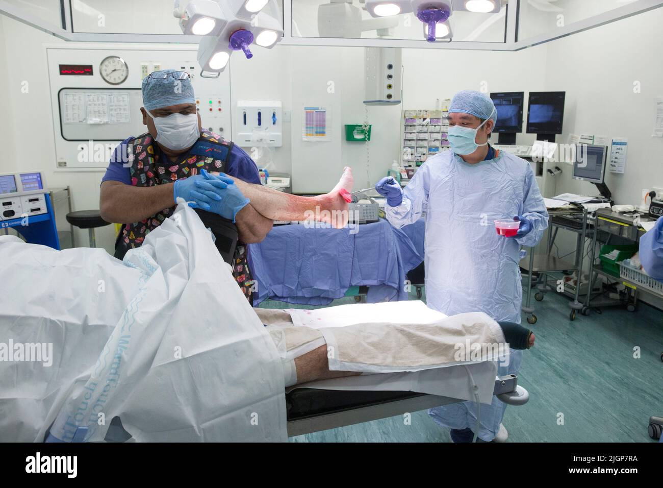 Hospital staff prepare a patient for foot surgery. The NHS is under pressure following severe cuts and staff shortages. Stock Photo
