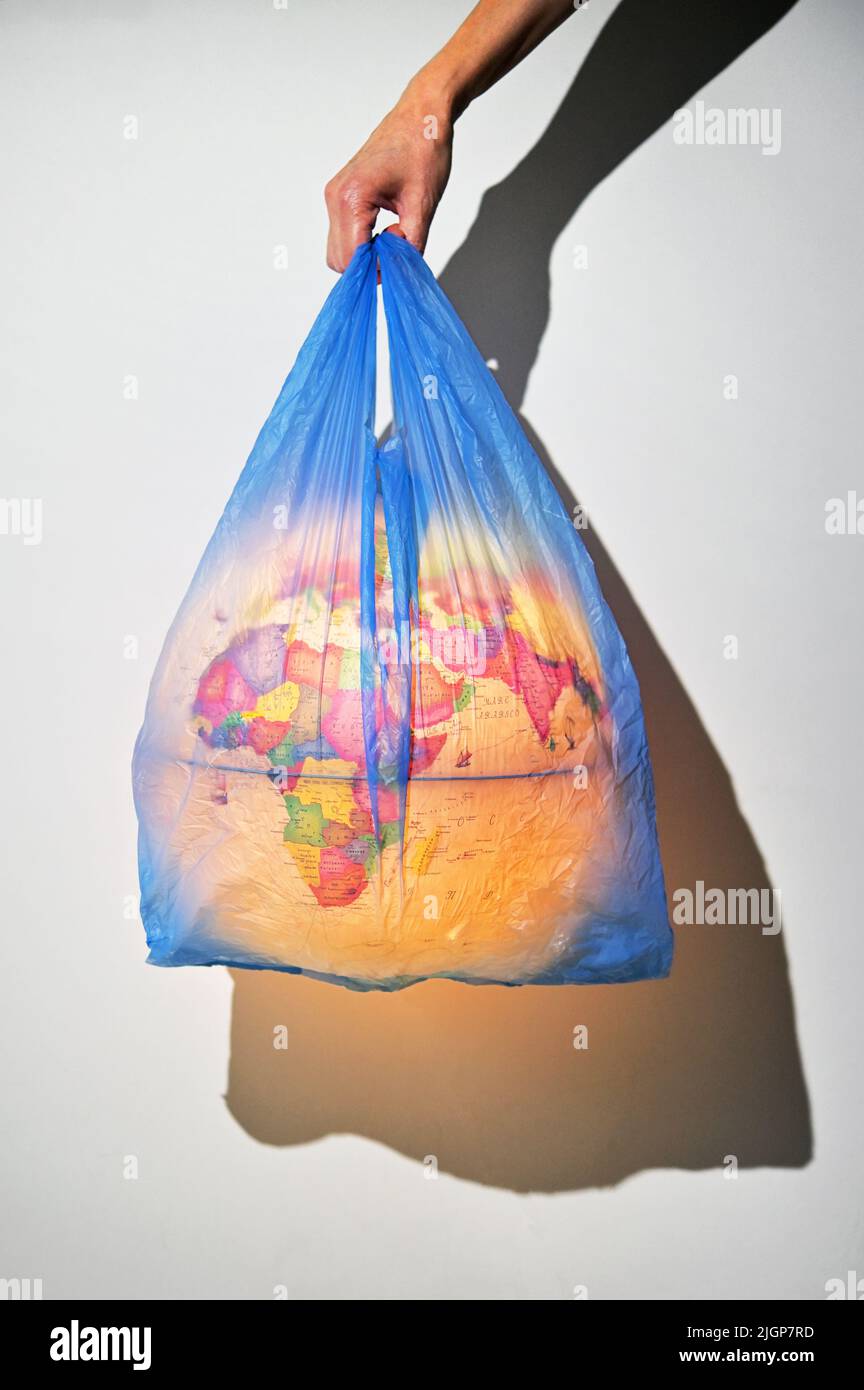 Concept Of Woman Holding Earth Globe Cover with Plastic Waste Pollution. Stock Photo